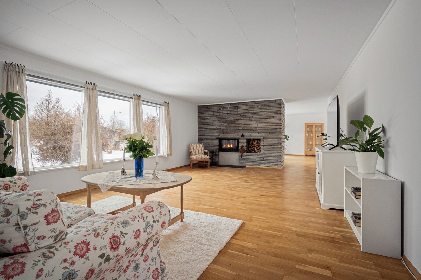 Stuen er svært romslig og lett å møblere, med gode soner for både avslapning og sosialt samvær. Peisen er pent integrert i skorstein med peisinnsats fra 2022. Galleribilde