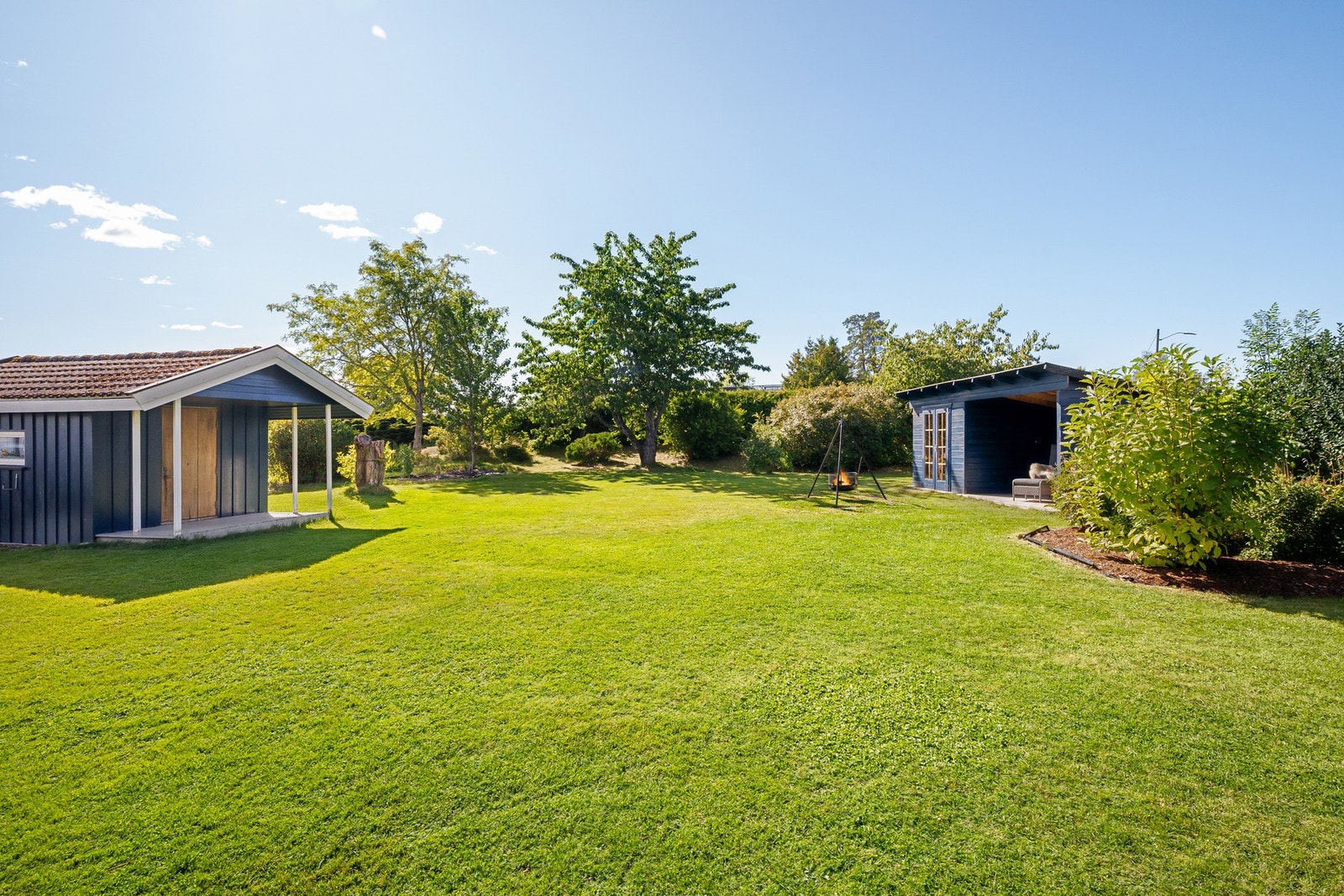 I hagen finnes også en hyggelig, overbygget hagestue/utehus som gir en lun og skjermet sone for sosiale sammenkomster, samt to uteboder som gir svært praktisk lagringsplass. Galleribilde