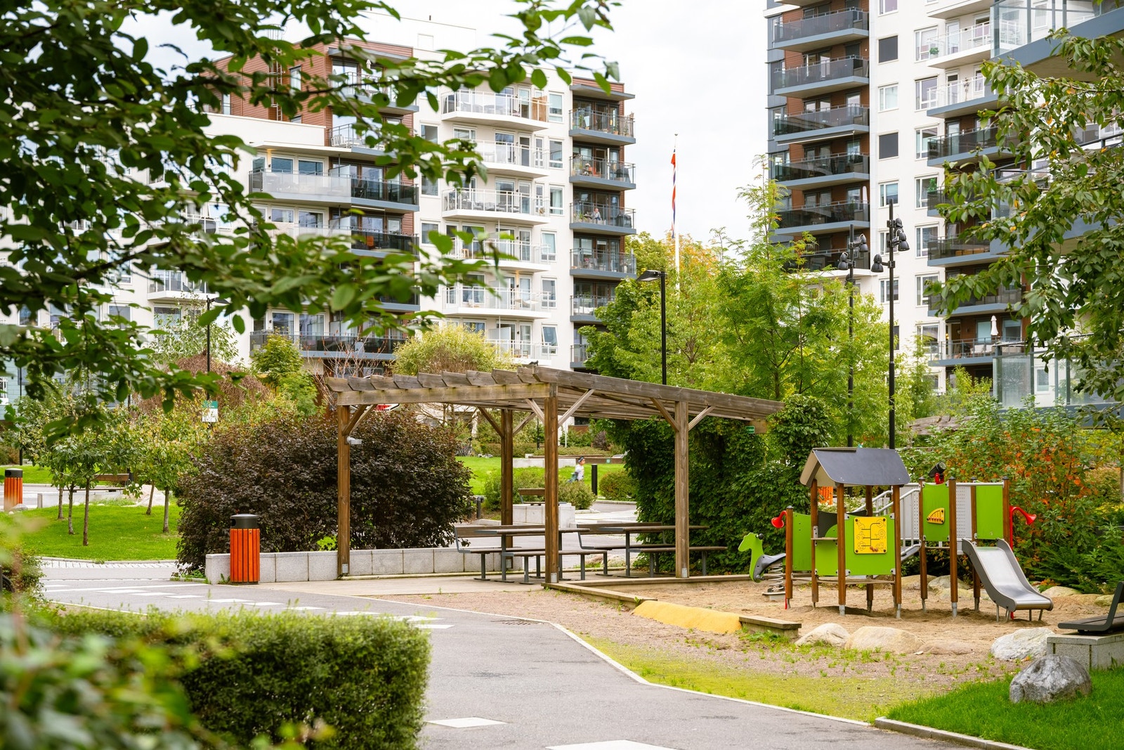Pent opparbeidet med lekeplass, sittesoner og beplantning. Galleribilde