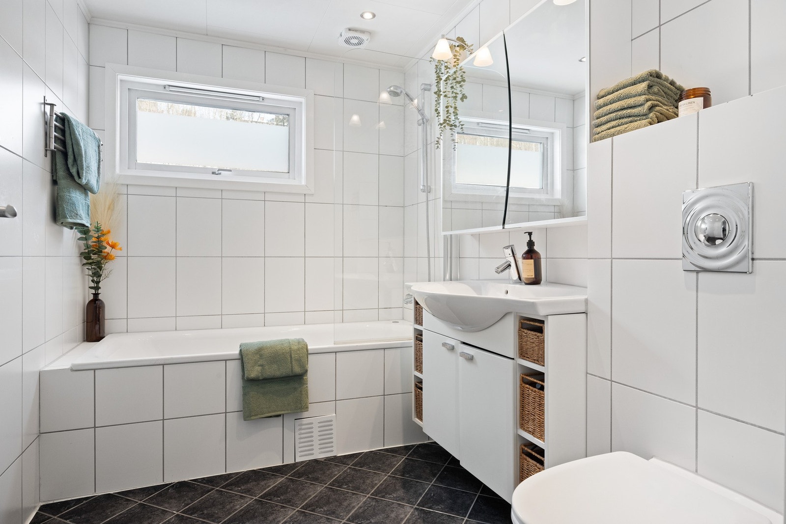 Flislagt baderom i andre etasje innredet med klosett, servant med servantskap, badekar og klosett. Galleribilde