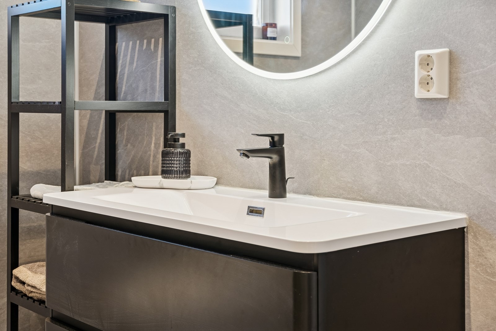 Sorte armaturer og detaljer gir badet et gjennomført og stilrent uttrykk. Galleribilde