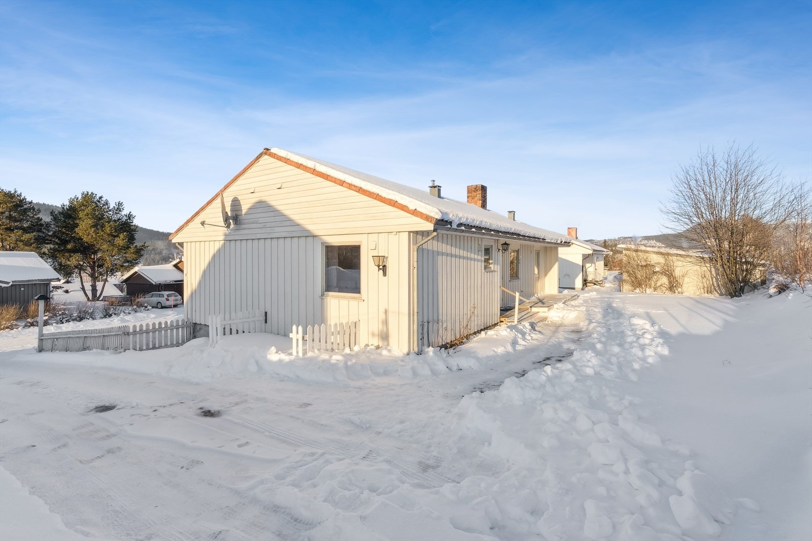 Boligen har en klassisk fasade med stående trepanel og saltak. Galleribilde