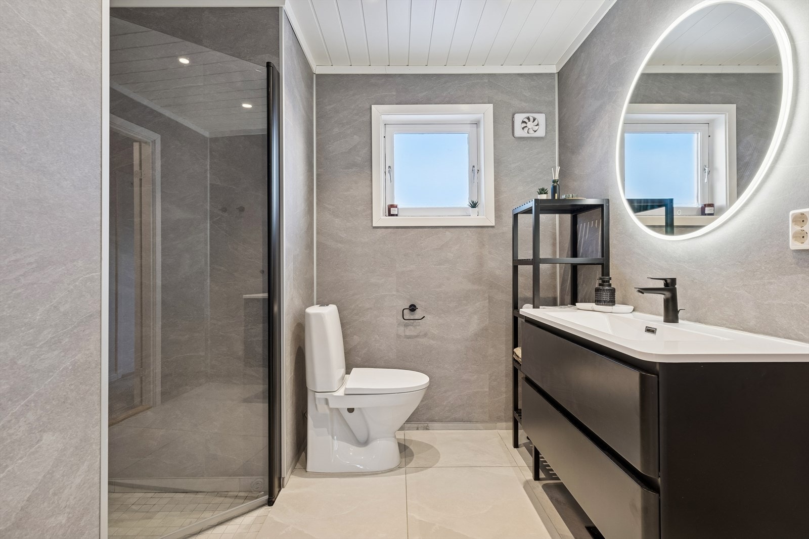 Pent og moderne bad med veggplater i gråtoner og lyse gulvfliser. Galleribilde