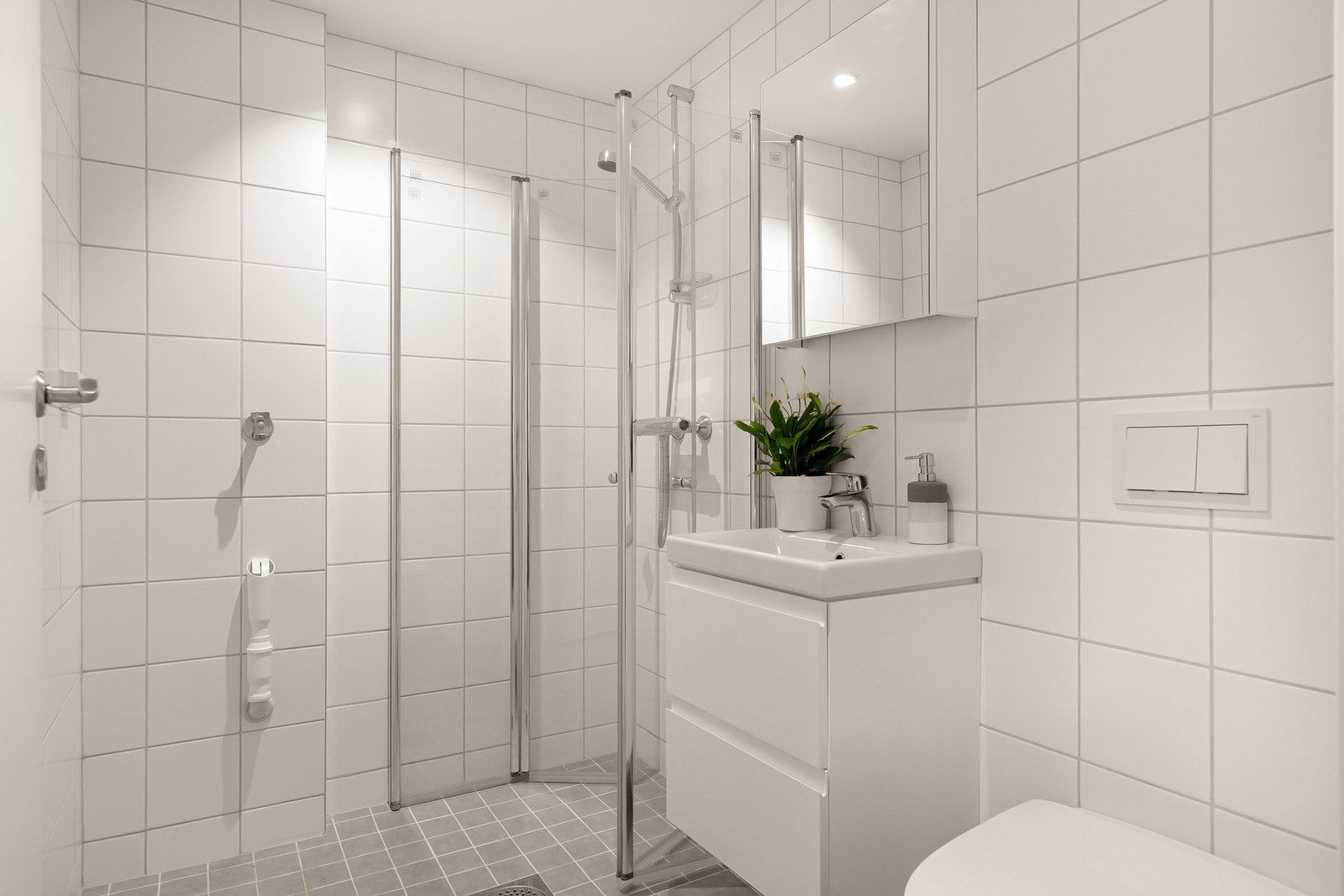 Flislagt bad med vegghengt servant og toalett. Galleribilde