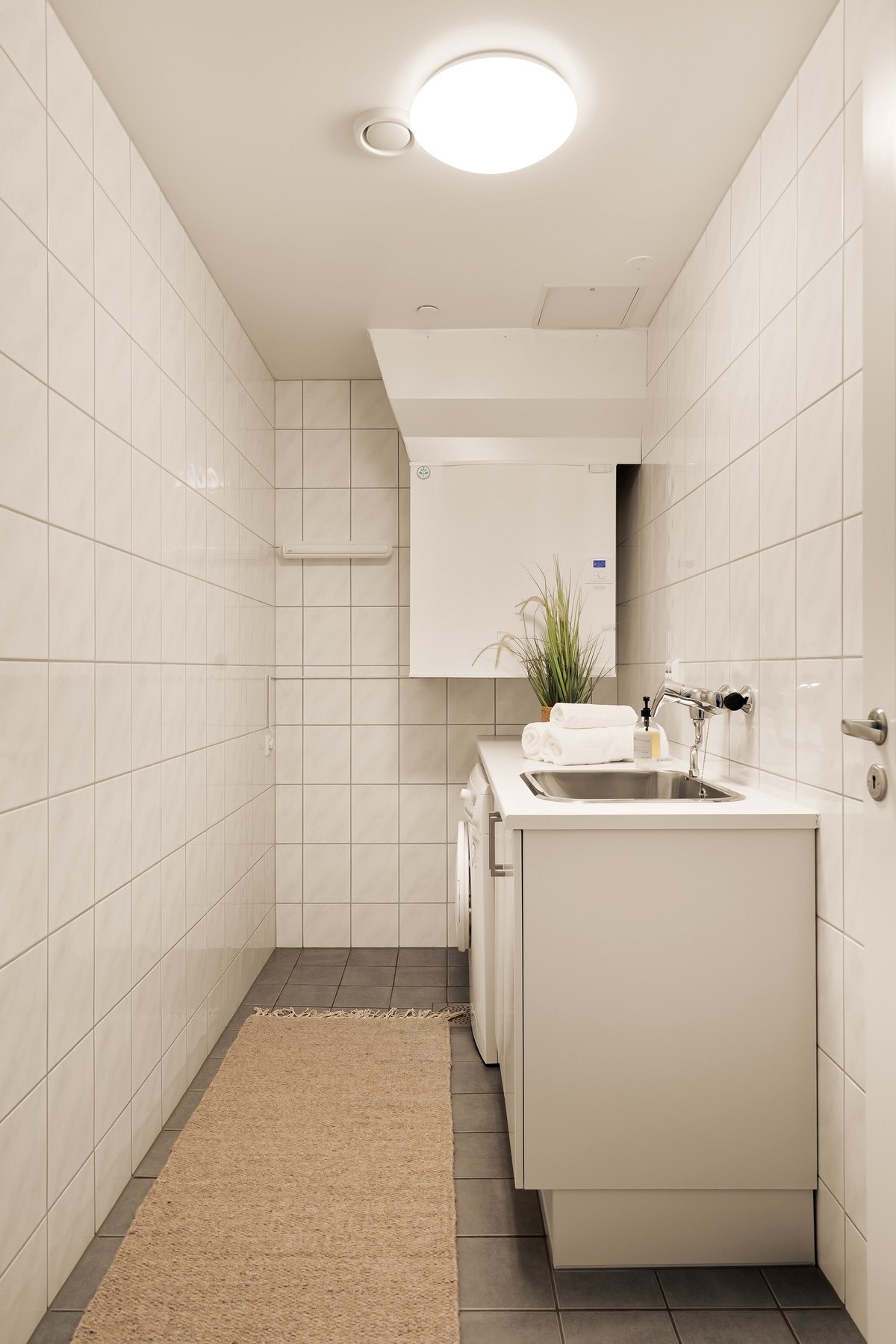 Separat vaskerom med fliser, gulvvarme og opplegg for vaskemaskin Galleribilde