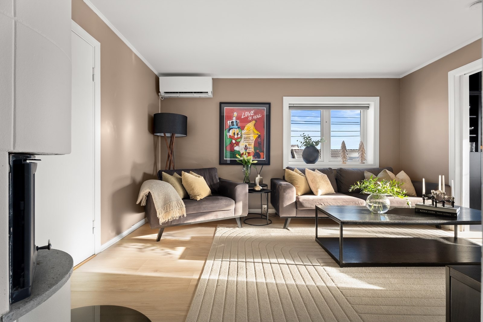 Stuen fremstår som et lyst og luftig oppholdsrom med store vindusflater. Galleribilde