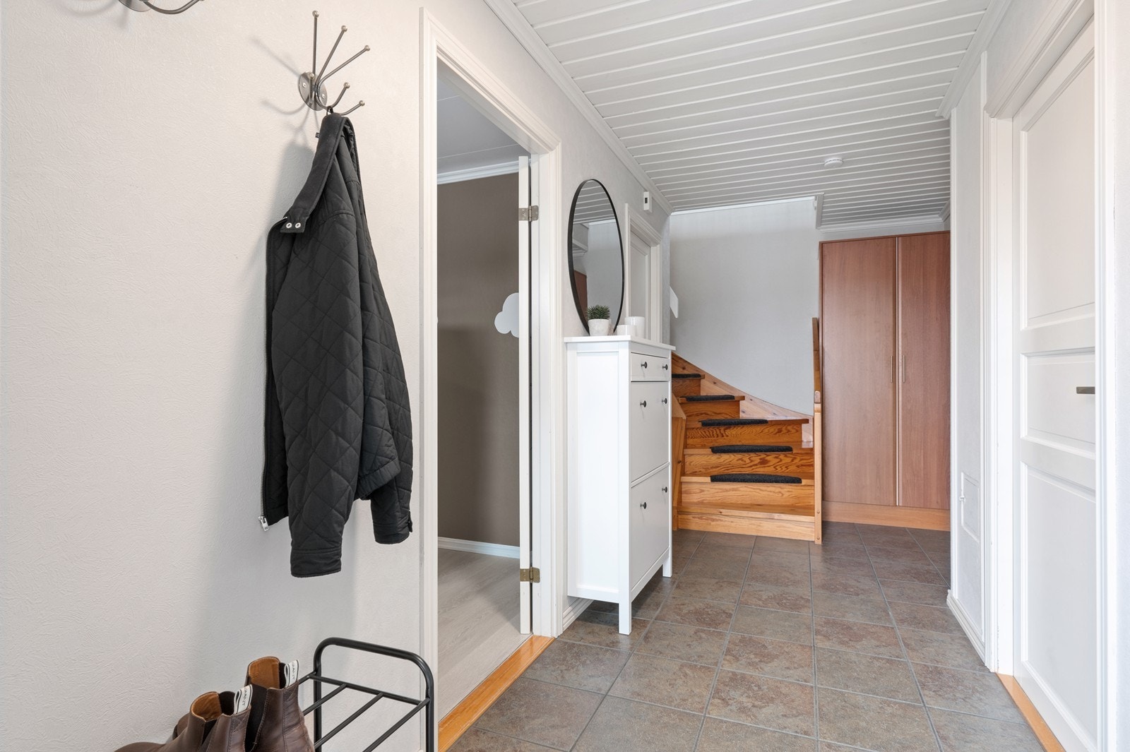 Entréen i underetasjen har flislagt gulv med elektrisk gulvvarme og tilgang til alle rom i etasjen. Her er det plass til både entré-møbler og garderobeskap. Galleribilde