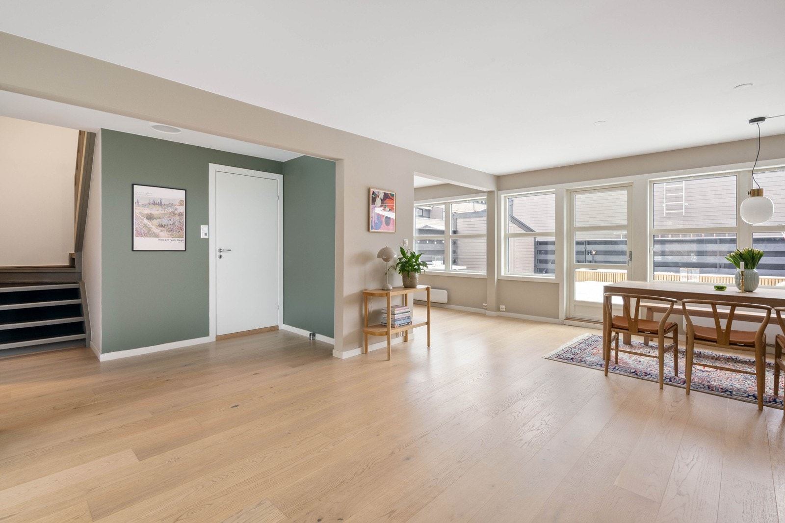 Store vindusflater og lys inn fra flere sider gjør rommet lyst og luftig Galleribilde