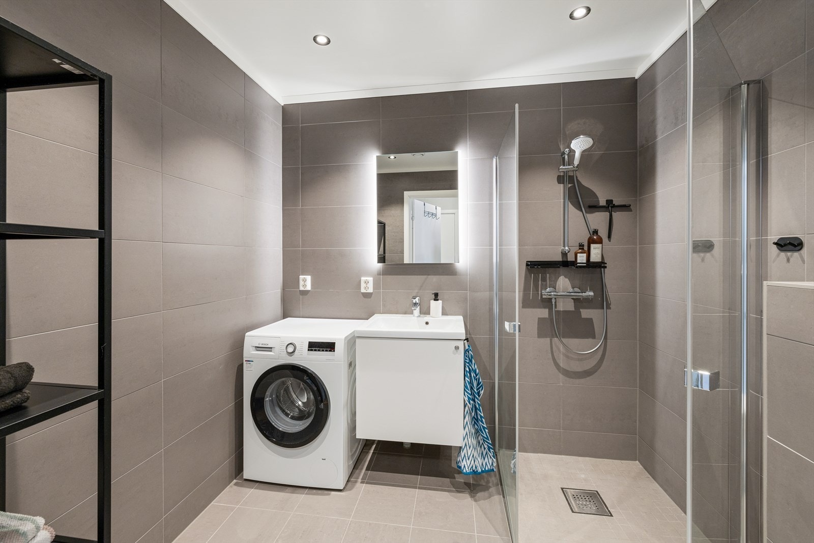 Badet fremstår som moderne og delikat, med fliser på både gulv og vegger samt malte plater i himlingen. Galleribilde