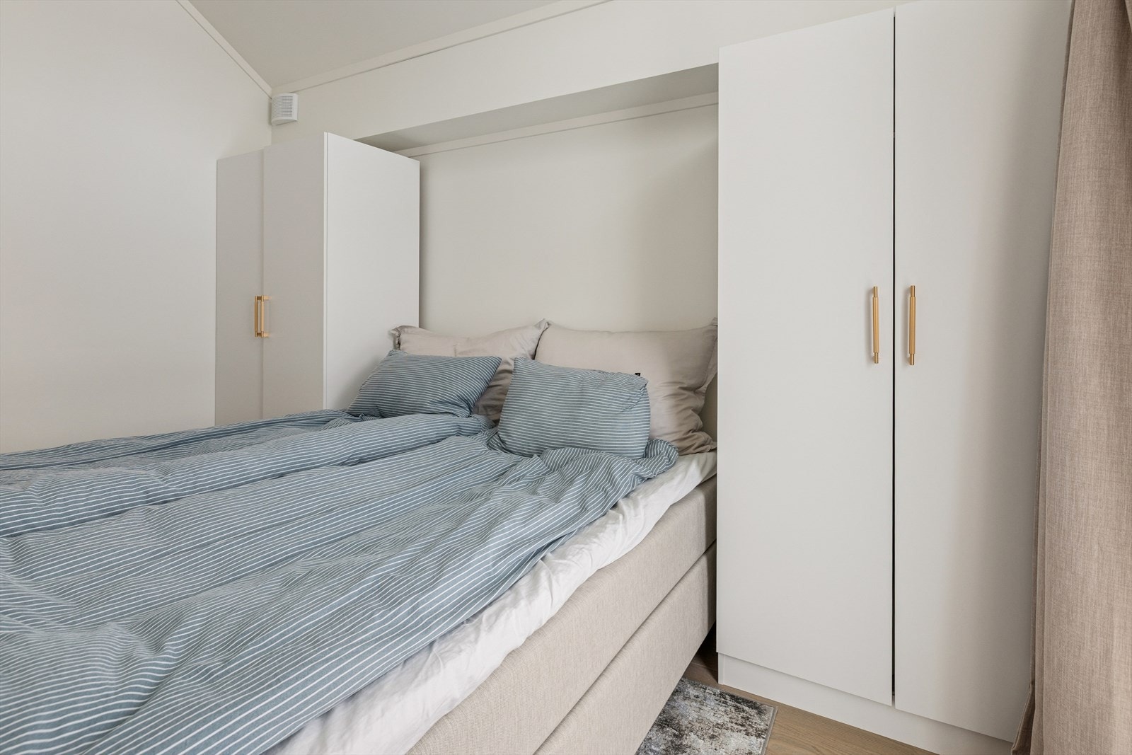 I dag er rommet møblert med frittstående garderobeskap på hver side av sengen, noe som gir gode oppbevaringsmuligheter uten å gå på bekostning av romfølelsen. Galleribilde