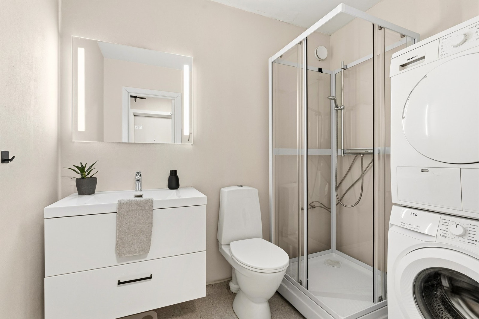 Badet er pent innredet med baderomsmøblement, dusjkabinett, opplegg til vask og tørk, samt toalett. Galleribilde