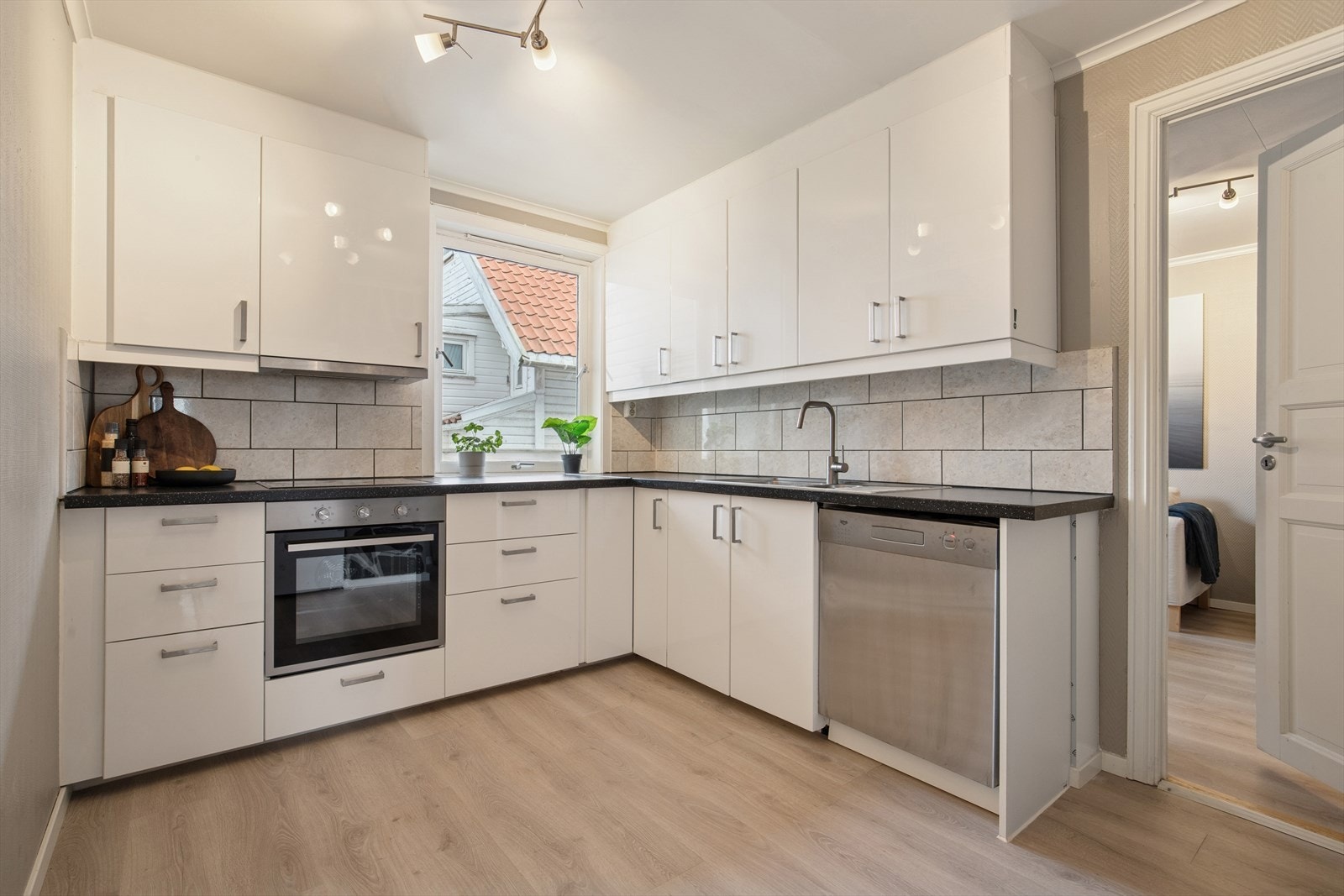 Kjøkkenet er tidløst innredet med hvite, slette fronter og mørk benkeplate i laminat. Et godt utnyttet kjøkken hvor man får godt med skap- og skuffeplass, samt gode arbeidsflater på benk. Galleribilde