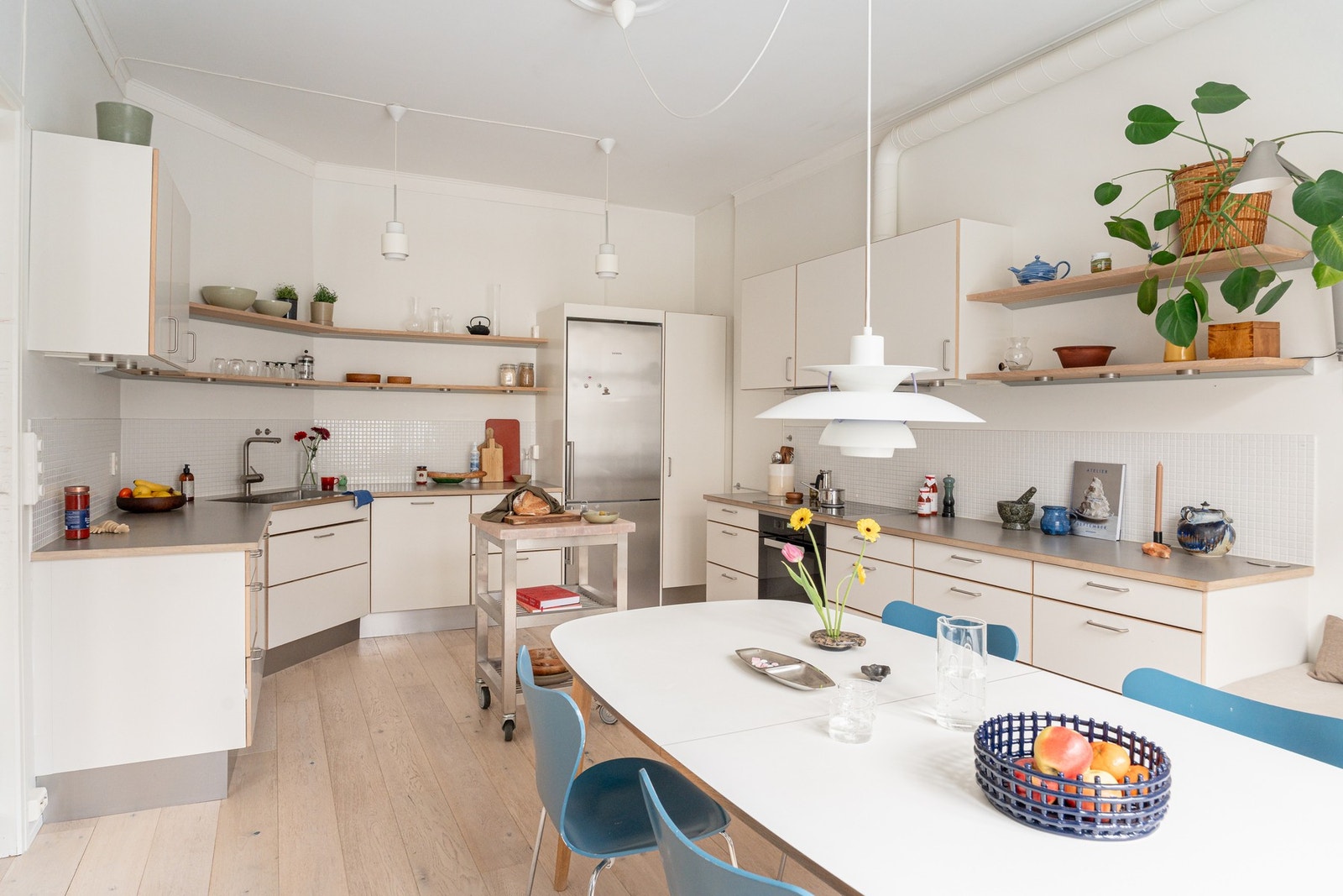 Innredningen har glatte fronter og gode arbeidsflater, med planlimt kum i rustfritt stål og fliser på vegg over benkeplaten. Galleribilde