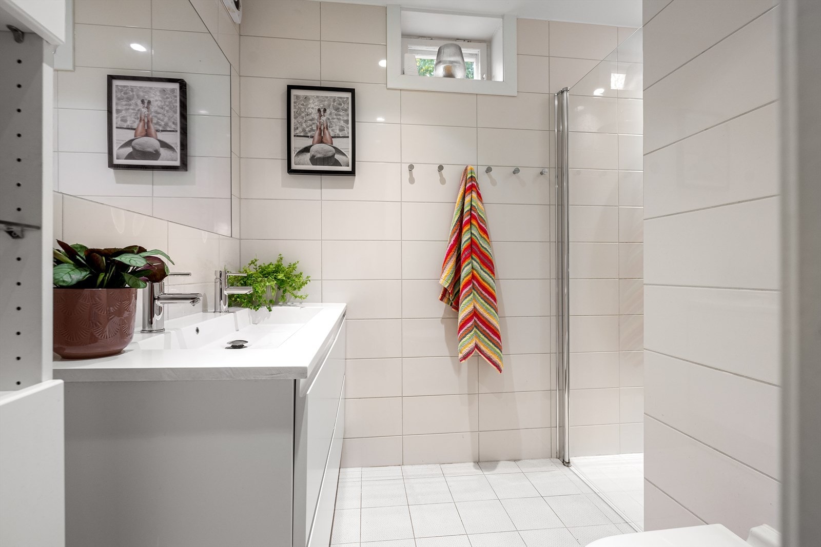 Lekkert bad fra 2019 innredet med dusjnisje med glassdør, toalett og dobbeltservant i skuffeinnredning. Galleribilde