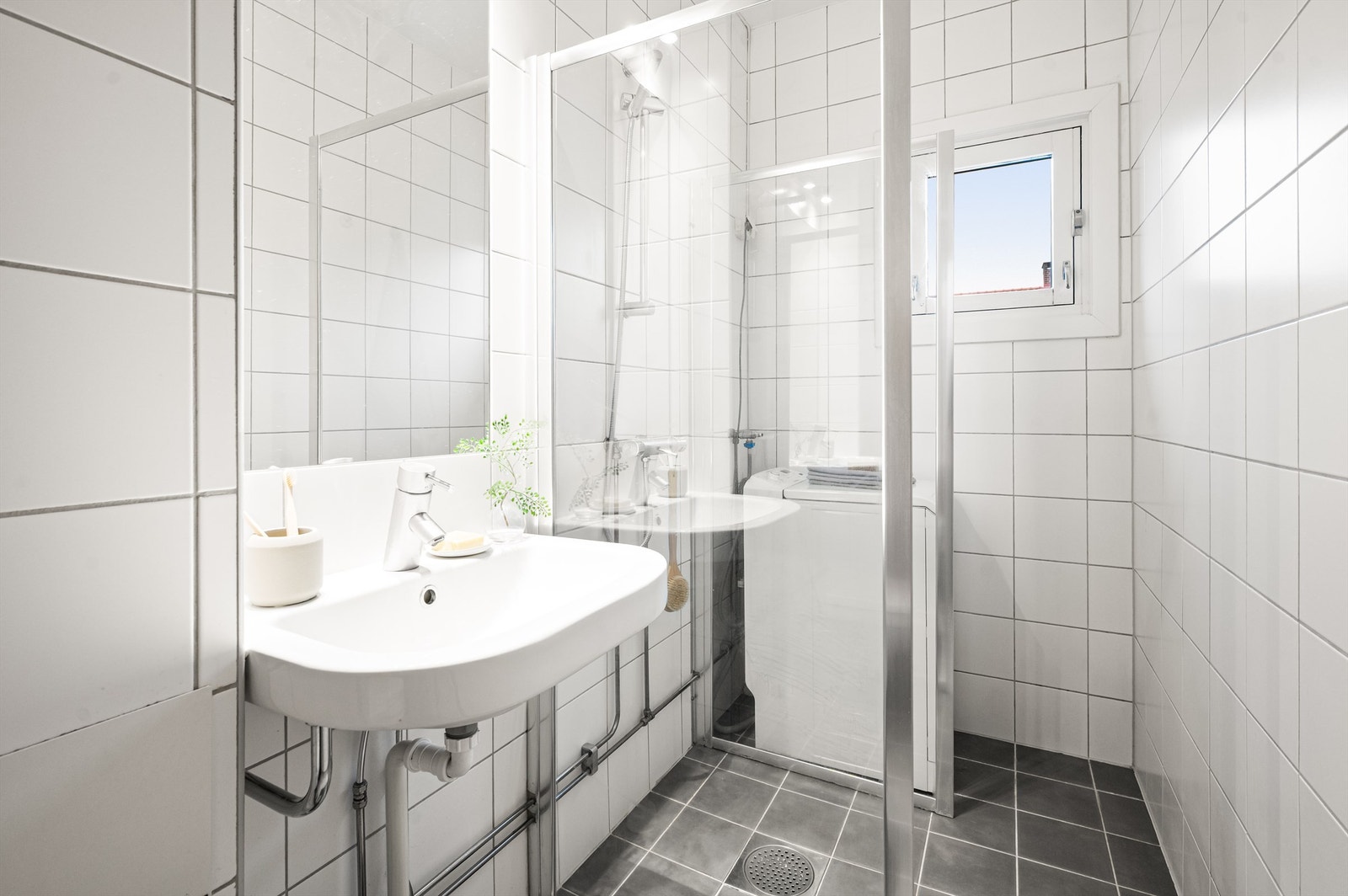 Himlingen er utført i malt flate. Badet er innredet med vegghengt servant med ettgreps armatur, speil og belysning over servant. Galleribilde