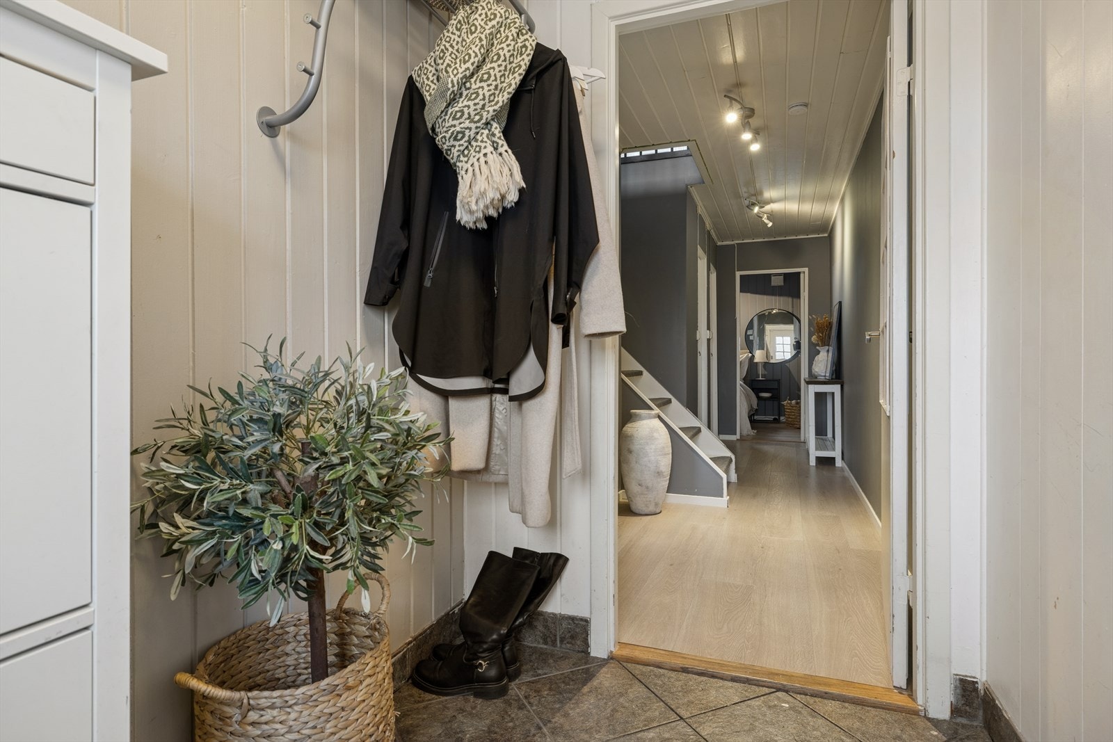 Her ønskes du velkommen inn i en flislagt entré med plass til å henge fra seg ytterklær. Galleribilde