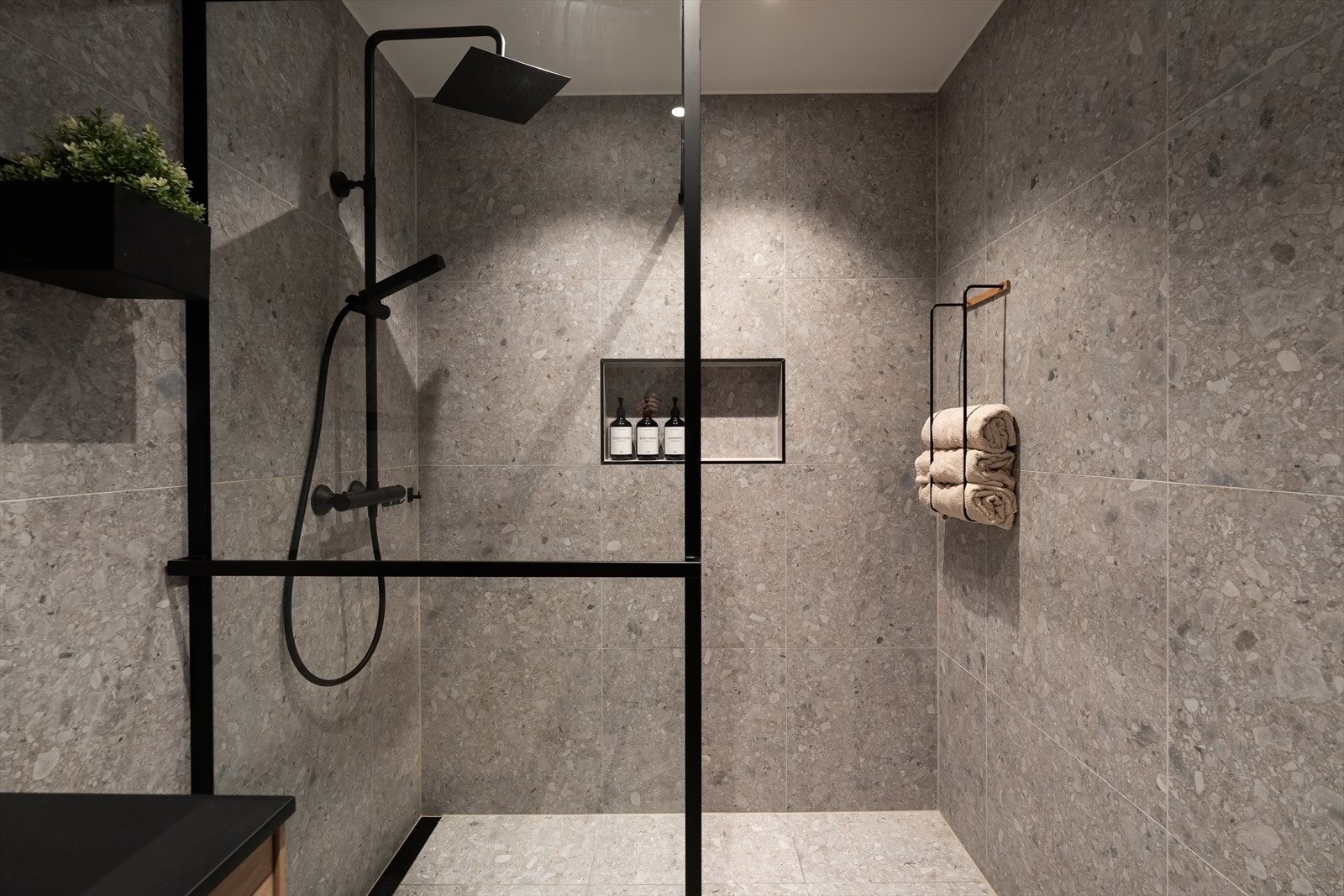 Badet har store terrazzo fliser, gulvvarme og downlightsbelysning. Galleribilde