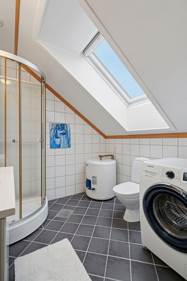 Flislagt bad med dusjkabinett, toalett, servant m/innredning og vaskemaskin Galleribilde