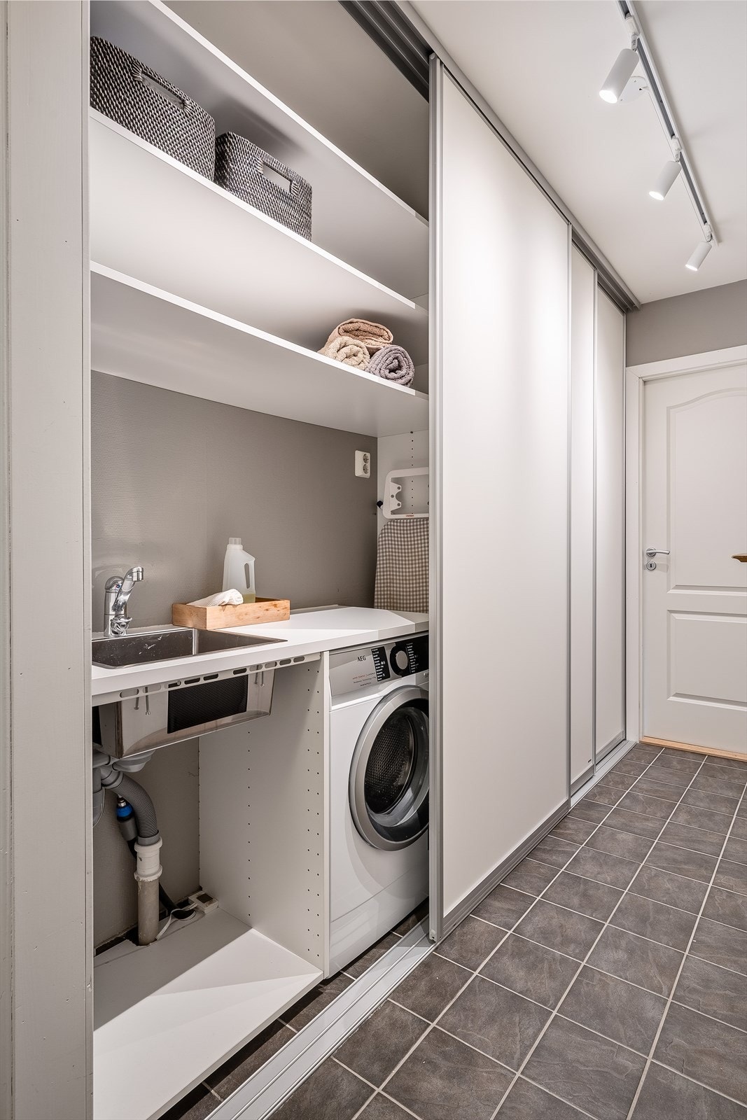 I bakkant av skyvedørsgarderoben finner du en praktisk løsning med vaskerom og gode oppbevaringsmuligheter Galleribilde
