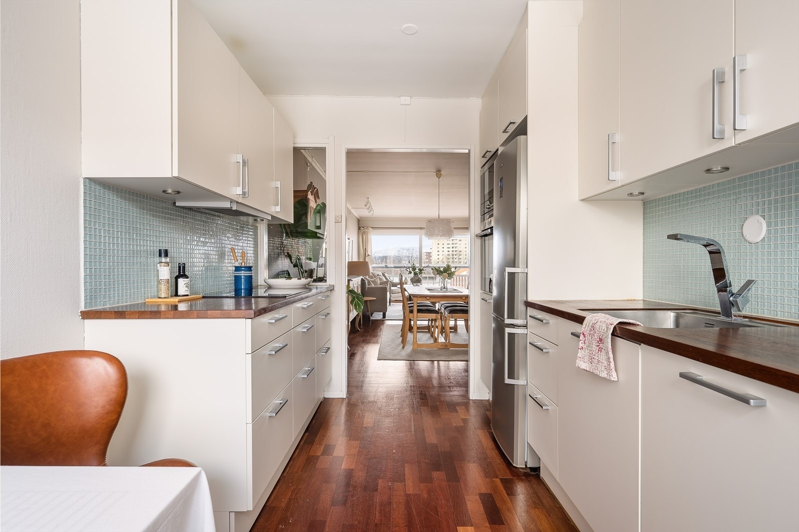 Hvite, glatte fronter og benkeplate i treverk med rustfri kum gir et rent og moderne uttrykk. Galleribilde