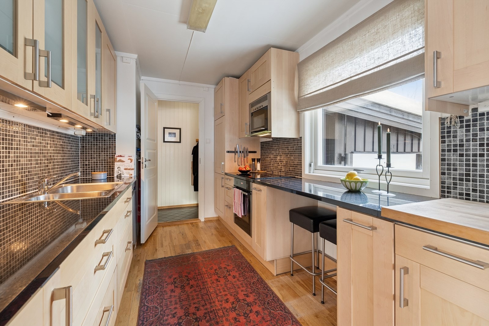 Det er belysning under overskapene og dekorative fliser i benkeryggen. Galleribilde