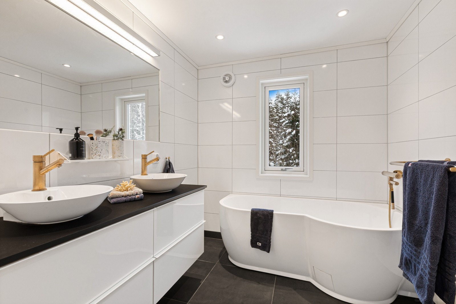 Delikat bad, renovert i 2019, med badekar og dobbel servant - en stilren og komfortabel løsning som gir en liten følelse av hverdagsluksus. Galleribilde