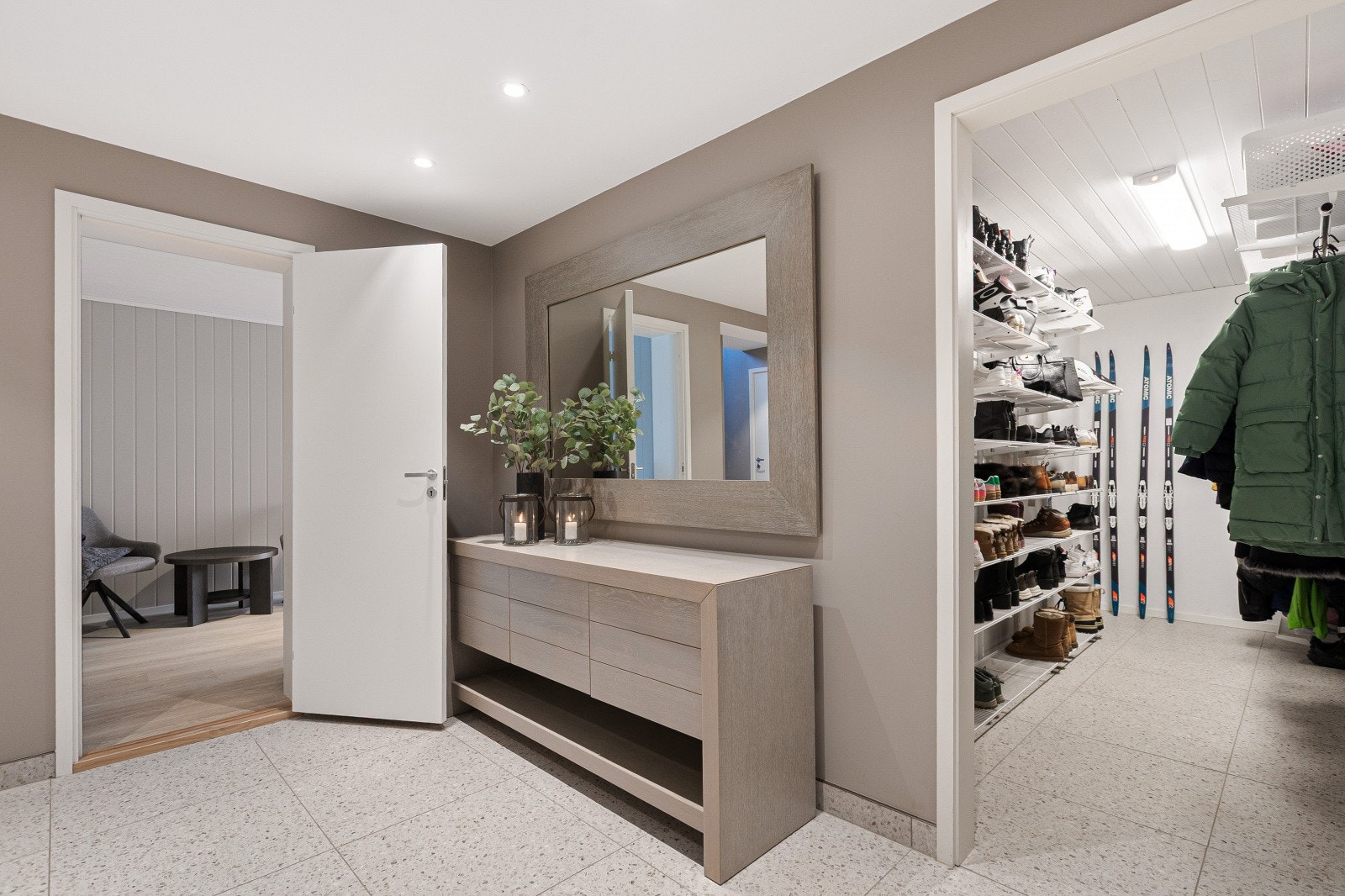 Legg merke til det praktiske garderoberommet i tilknytning til entréen. Rommet er innredet med Elfa-system som gir rikelig med plass til oppbevaring av ytterklær, sko og annet utstyr Galleribilde