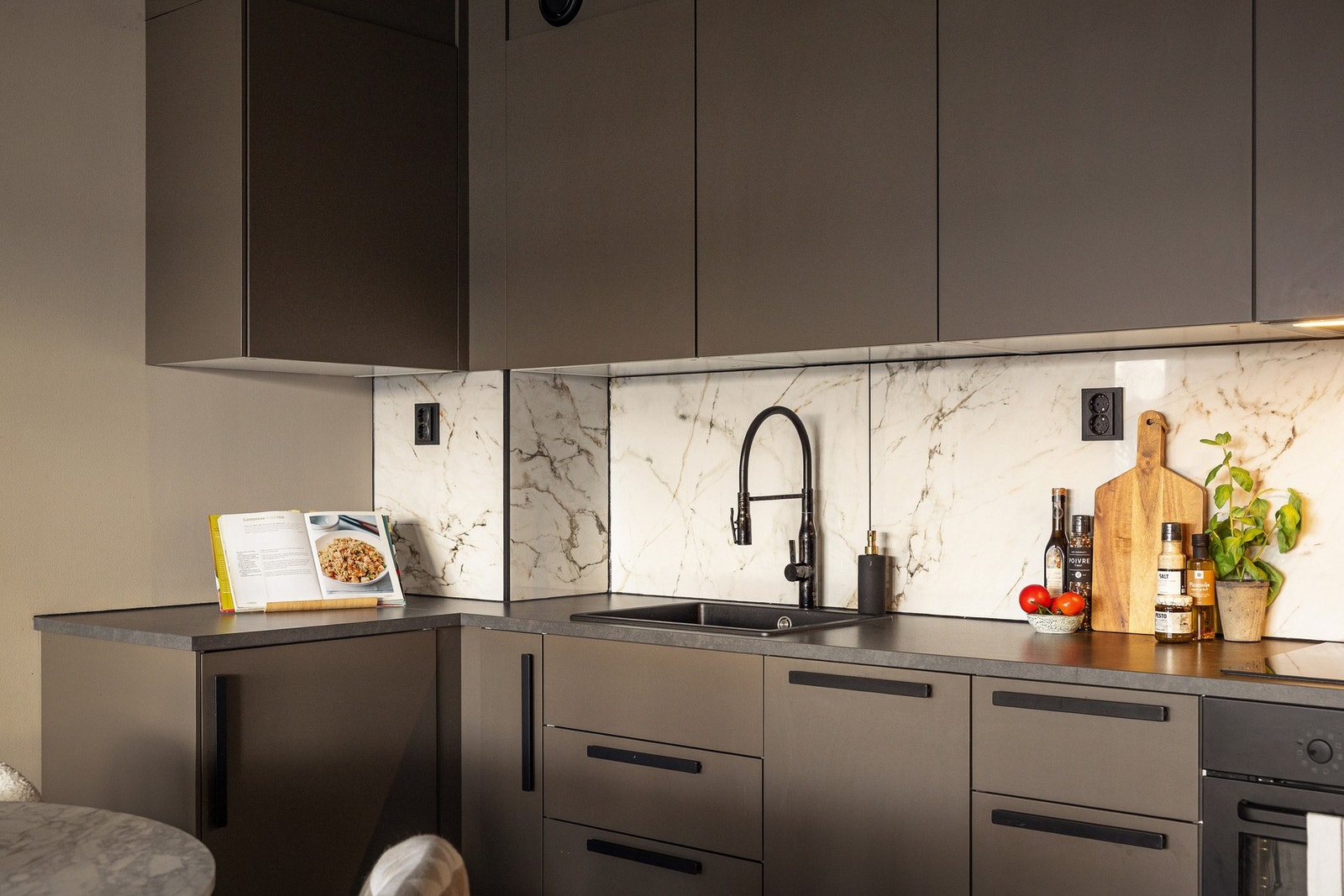 Innredningen har slette, mørke fronter som gir et stilrent og eksklusivt preg, kombinert med slanke, sorte håndtak som understreker det stramme designet. Galleribilde