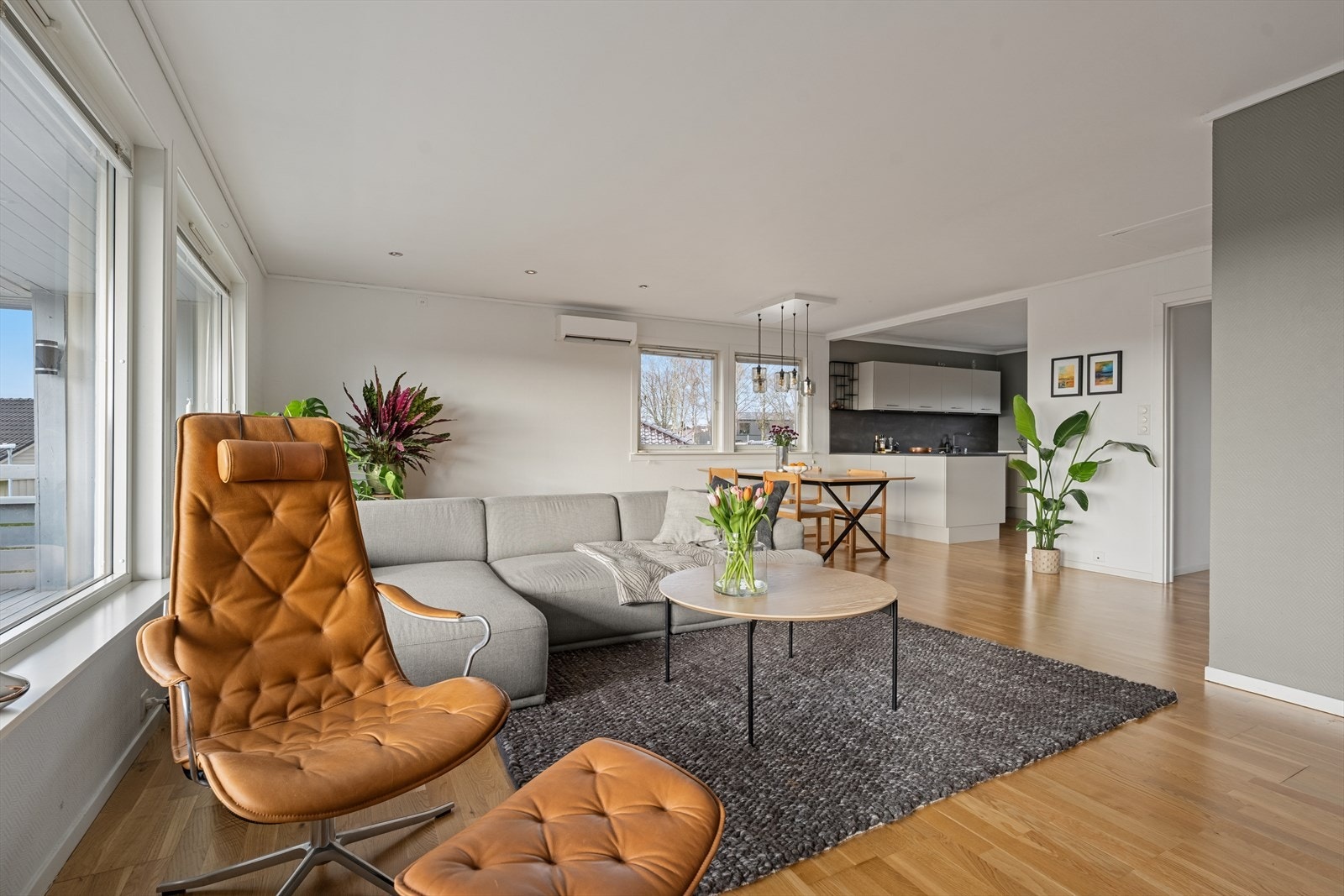 Boligens sosiale sone med stue og kjøkken ligger i åpen løsning. Et lyst og innbydende rom med store vindusflater som gir rikelig med naturlig lys. Galleribilde