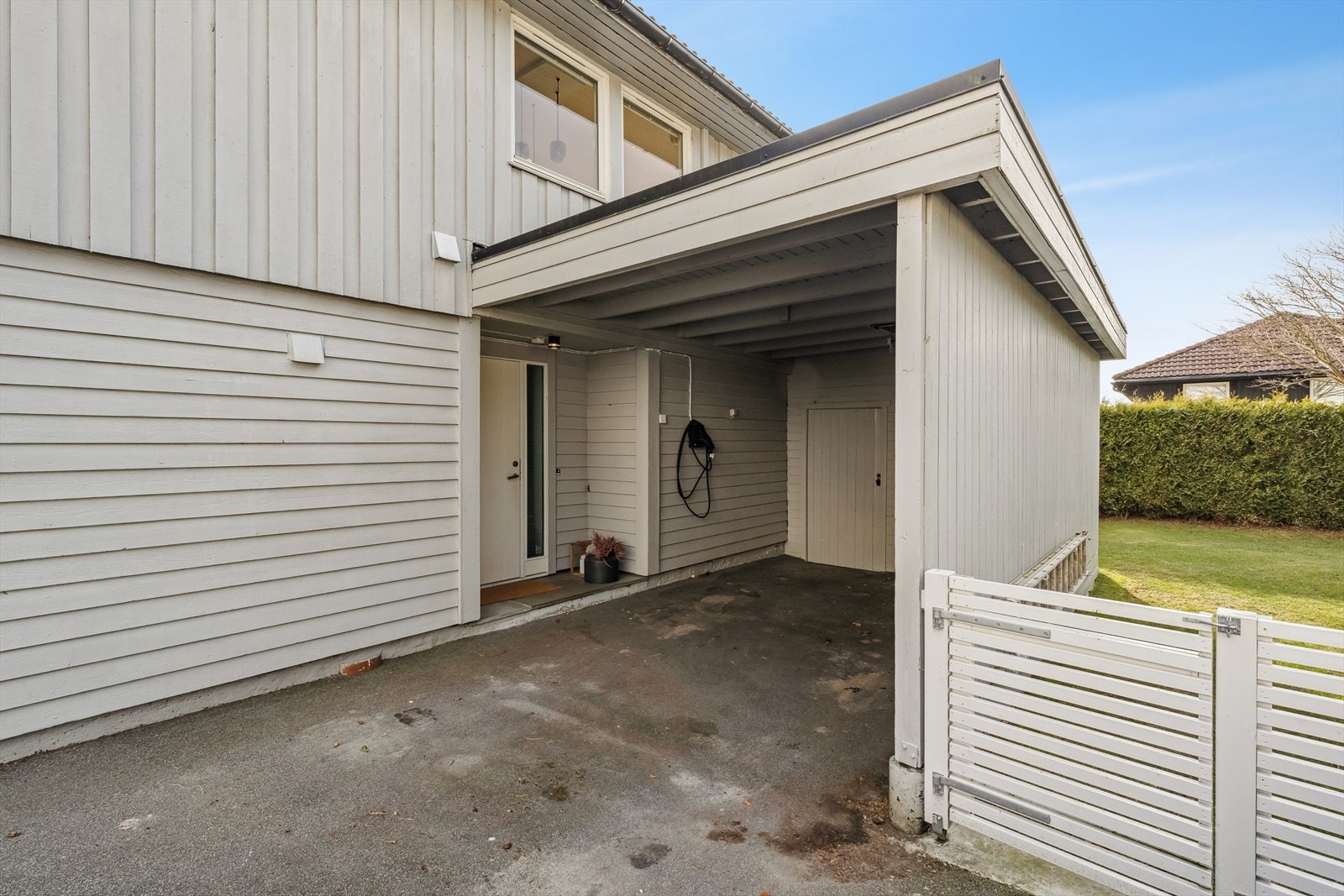 Parkering i carport med elbillader fra 2025. I bakkant av carporten har man en bod som gir ekstra lagringsplass. Galleribilde