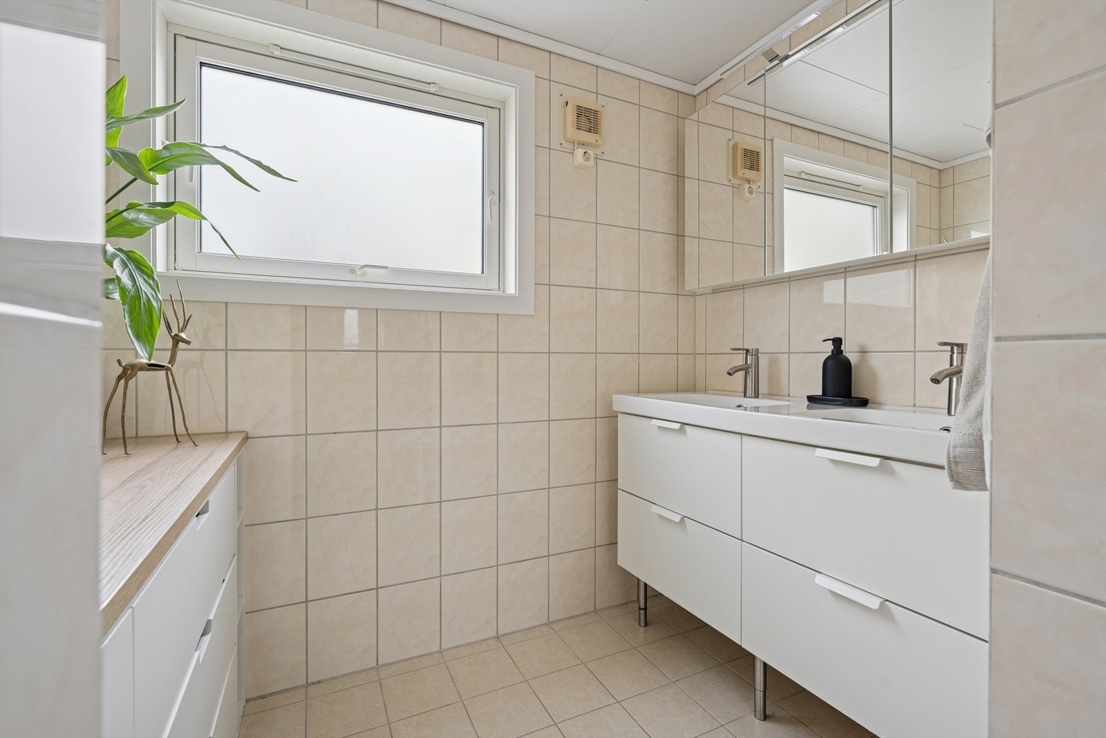 Badet er ellers utstyrt med dusjkabinett, vegghengt toalett og baderomsinnredning med god lagringsplass og dobbel servant. Galleribilde