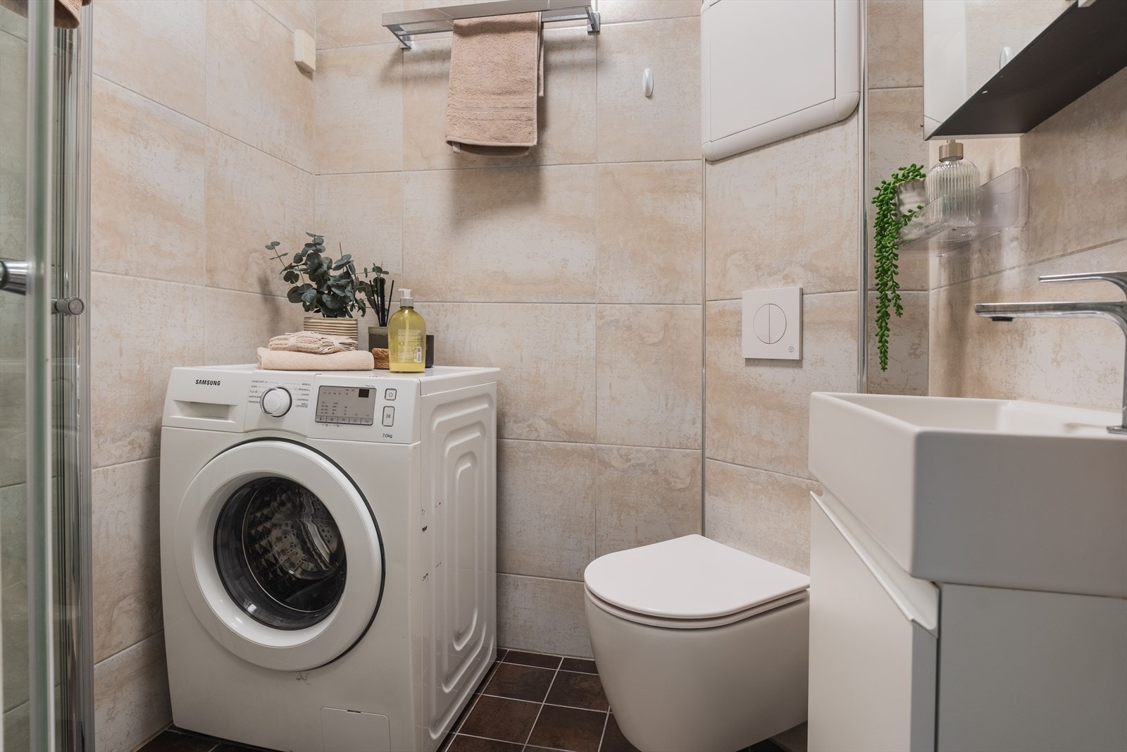 Pent flislagt baderom fra 2011 med innfellbar dusjnisje, vegghengt wc, servantskap og opplegg for vaskemaskin/tørketrommel. Galleribilde