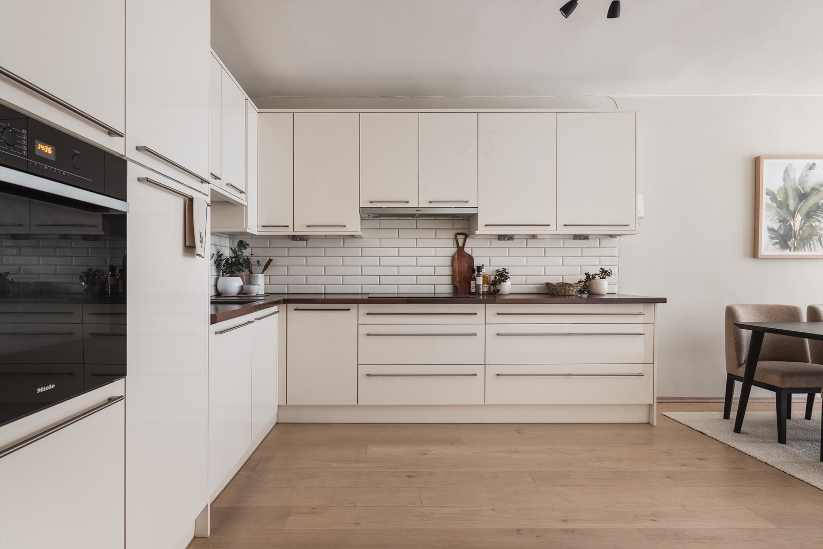 Kjøkkenet har rikelig med benke og skapplass, integrerte hvitevarer og pent flislagt bakvegg. Galleribilde