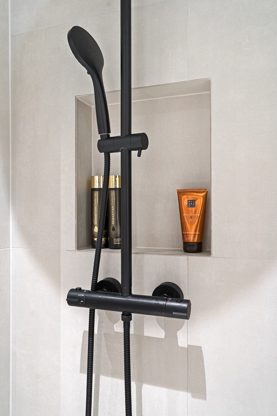 Praktisk hyllenisje i dusjsonen gir et ryddig og stilrent baderom Galleribilde