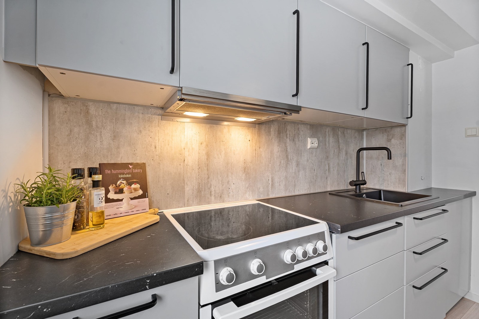 Kjøkkeninnredning fra IKEA med god skap- og benkeplass med lun farge og stilige sorte detaljer Galleribilde