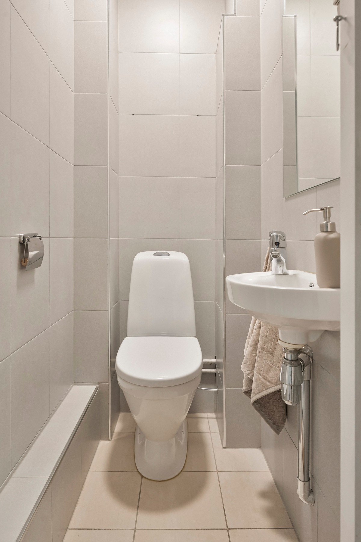 Vegg i vegg med badet finner du et flislagt toalettrom med gulvvarme. Galleribilde