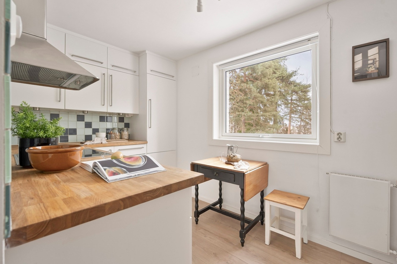 Kjøkkenet ligger i praktisk tilknytning til stuen og har plass til en spisebord ved vindu med utsyn mot grøntområde. Galleribilde