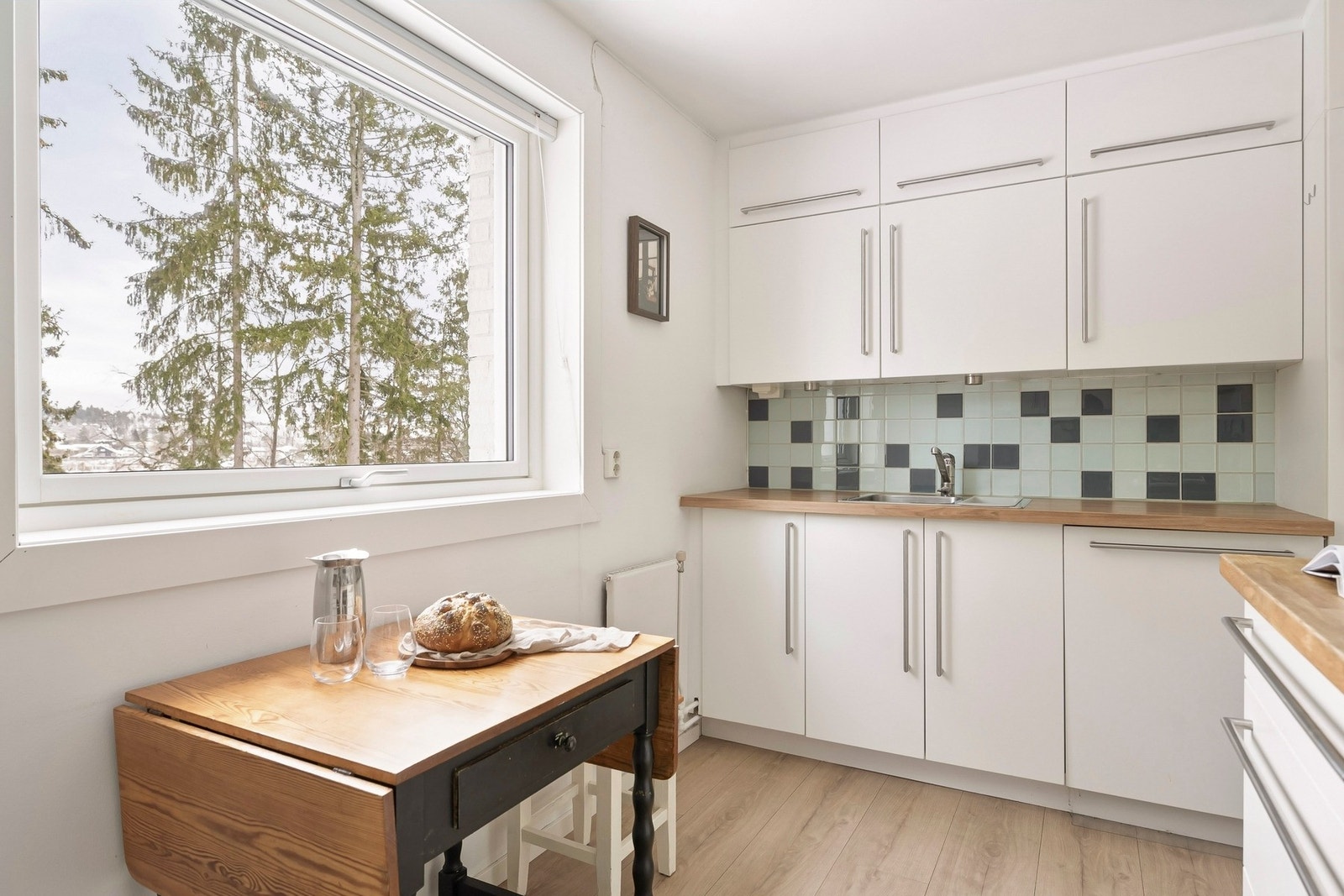 Flaten over kjøkkenbenker er belagt med flis, noe som bidrar til enkelt vedlikehold og forhindrer skader på vegg som følge av vannsprut eller stekeos. Galleribilde