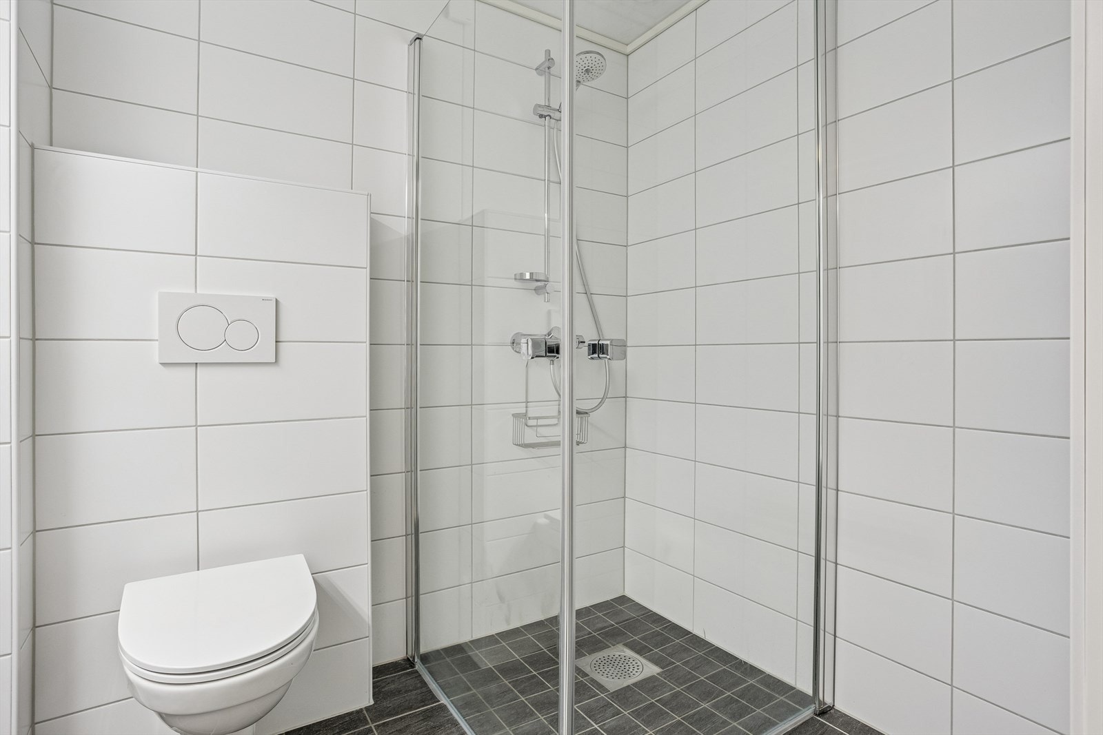 Badet har dusjhjørne med dører i klart glass og et rør-i-rørsystem. Galleribilde