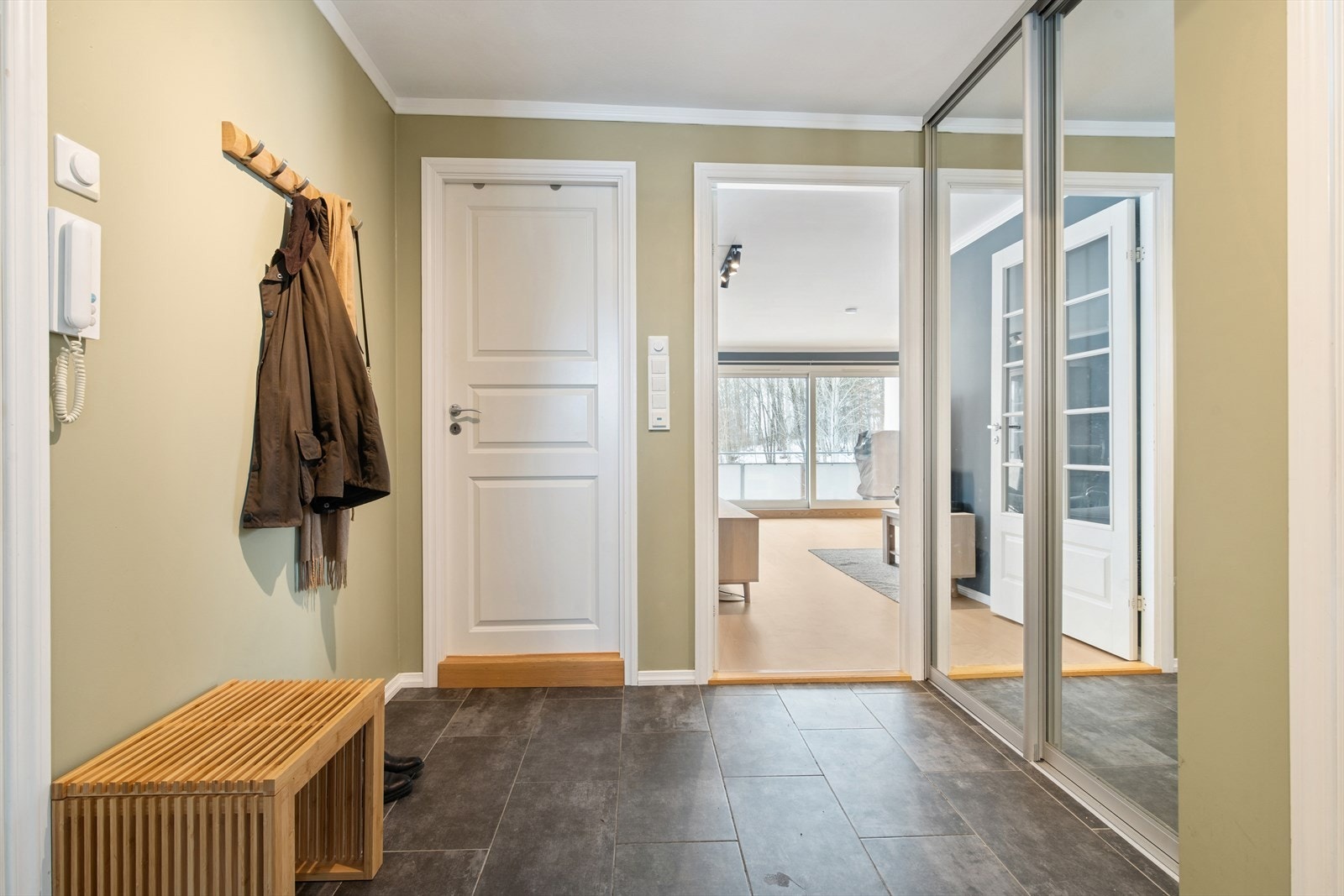 En innbydende entré med flislagt gulv og en romslig skyvedørsgarderobe ønsker deg velkommen inn. Galleribilde