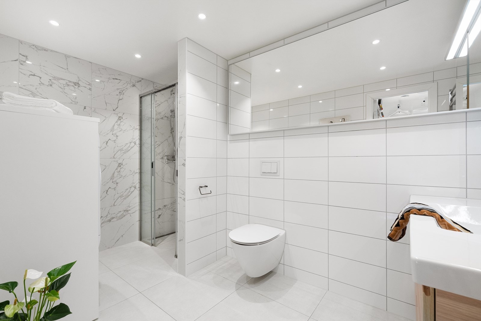 Flott, helfliset bad med varmekabler i gulv som bidrar til ekstra komfort i hverdagen. Badet har blitt betydelig påkostet utover en standardløsning. Galleribilde