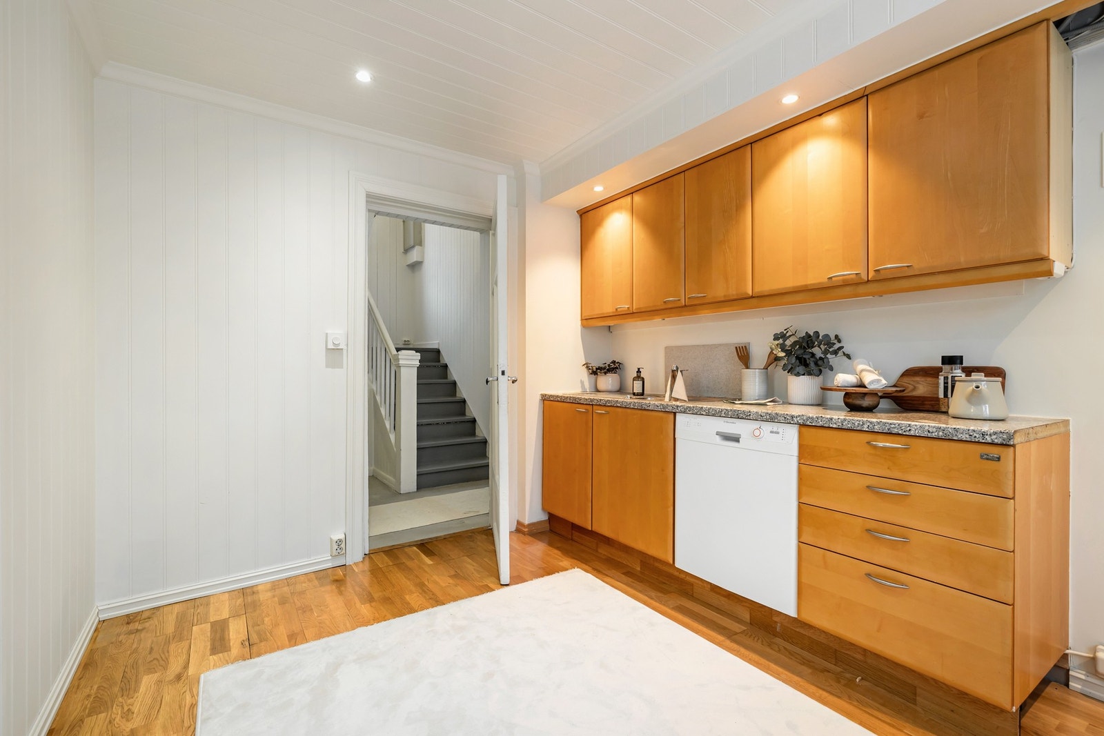 Benkeplaten er laminat med nedfelt kum og plate på vegg over arbeidsområdet. Innredningen består av både over- og underskap, samt integrert oppvaskmaskin. Galleribilde