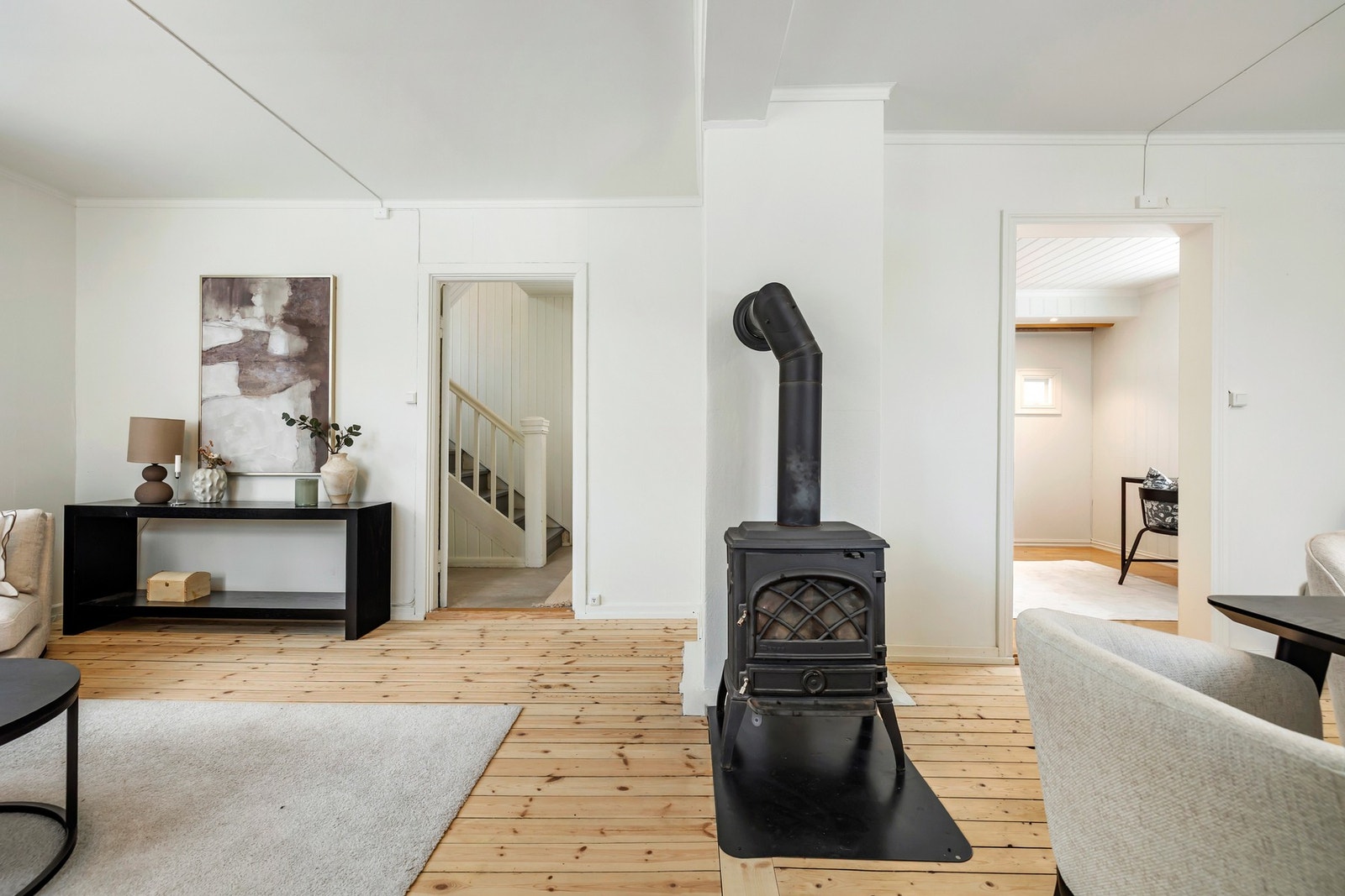 Den vedfyrte ovnen er plassert sentralt i rommet og fungerer som et naturlig midtpunkt Galleribilde