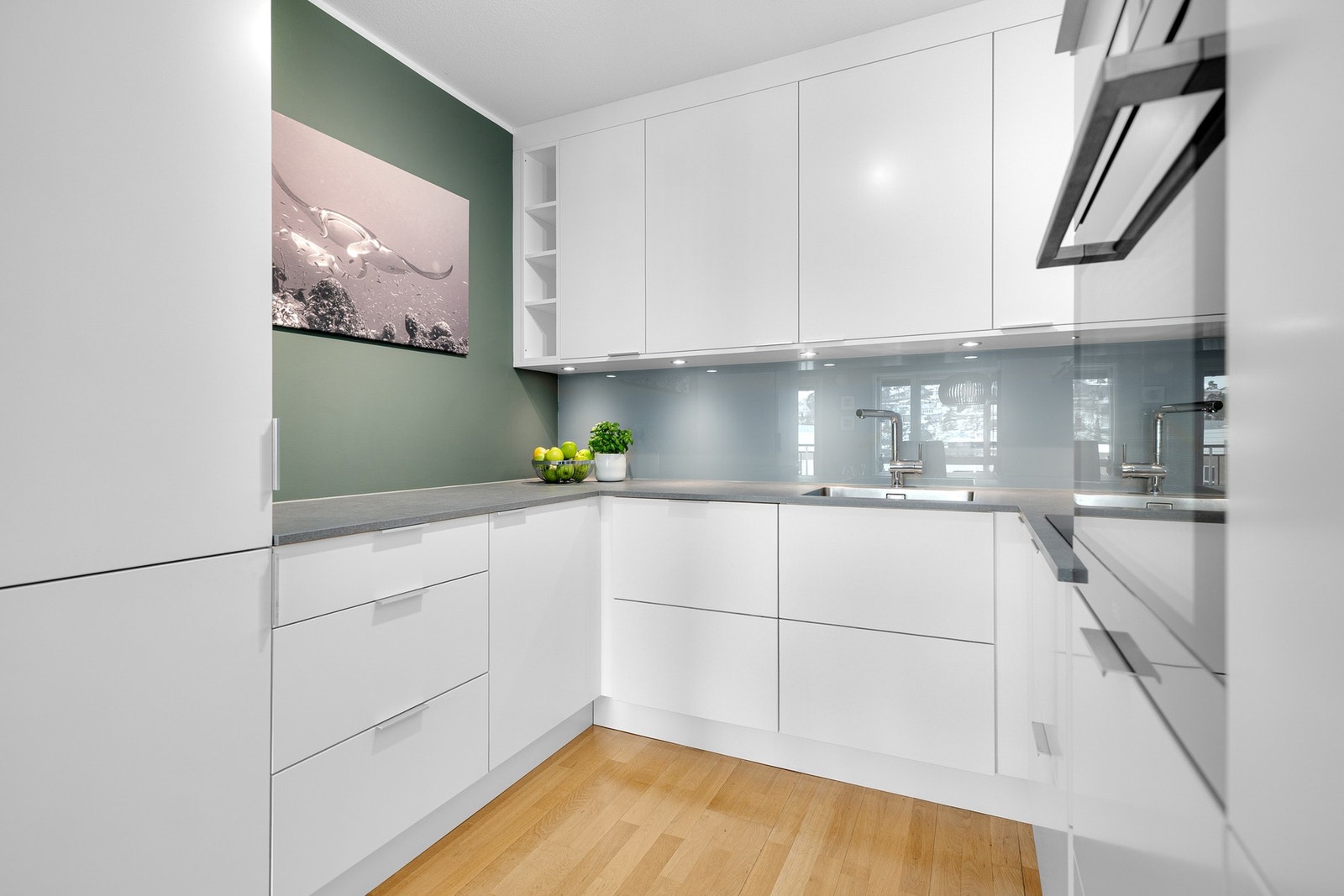 Godt med skap- og benkeplass gjør kjøkkenet både funksjonelt og stilrent. Innfelte LED-lys under overskap. Galleribilde