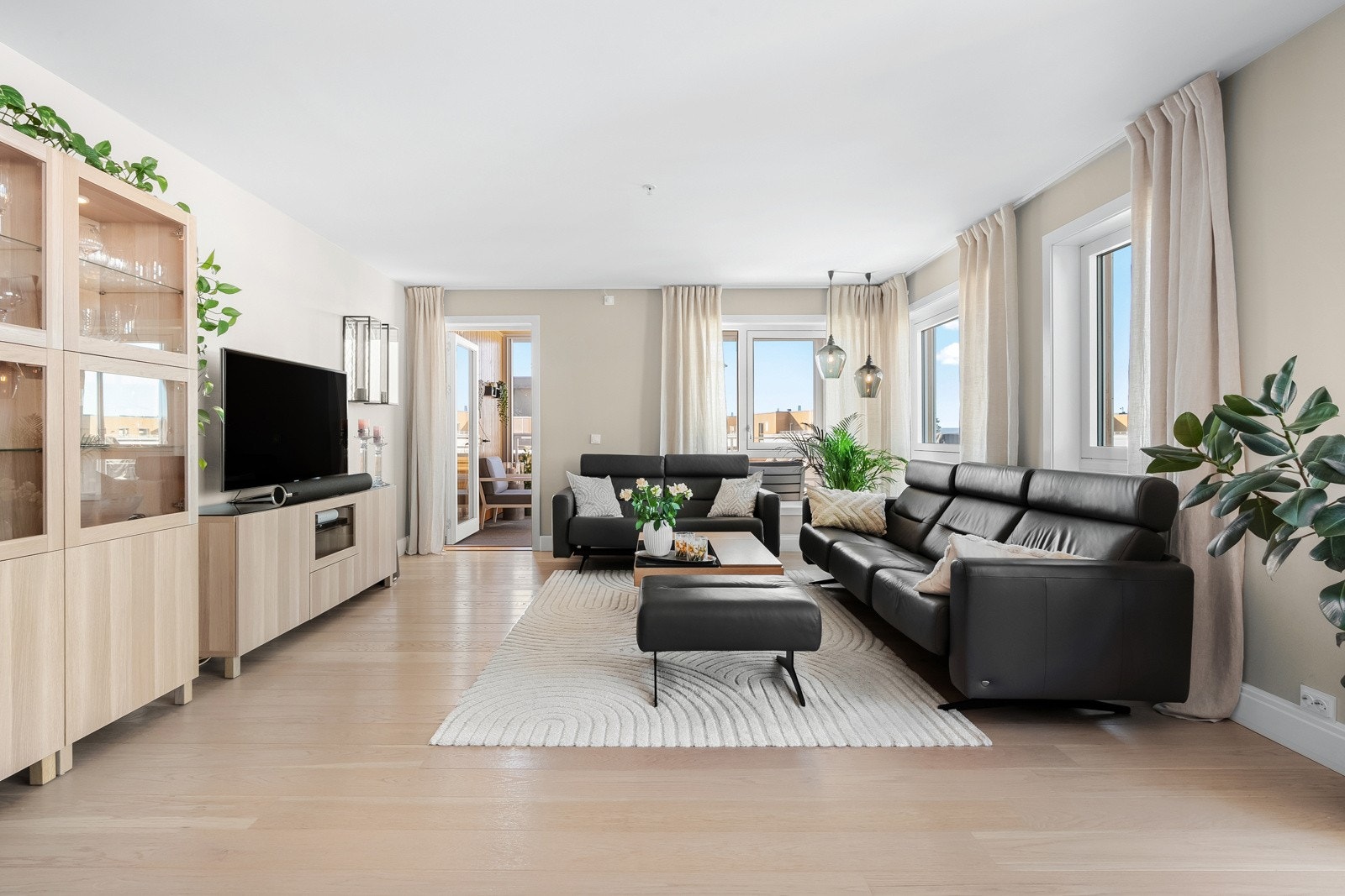 Overflatene i stuen fremstår som moderne med tidsriktige fargevalg og en-stavs parkett på gulv. Galleribilde