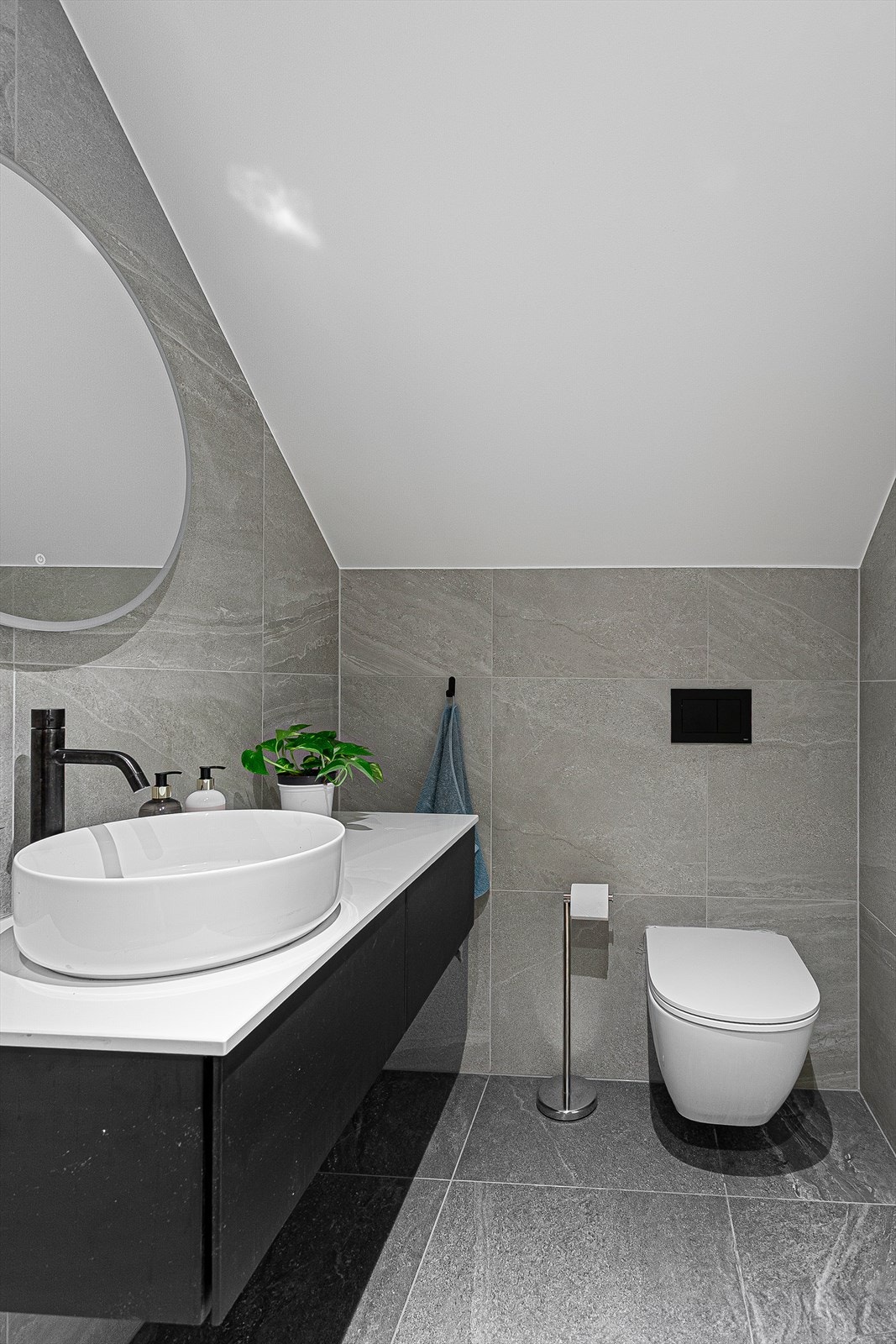 Pent flislagt bad 1 fra 2023 med adkomst fra loftstue. Downlights i himlingen. Innredet med vegghengt servantinnredning med skuffer og ovenpåliggende servant. Speil med sidelys. Galleribilde