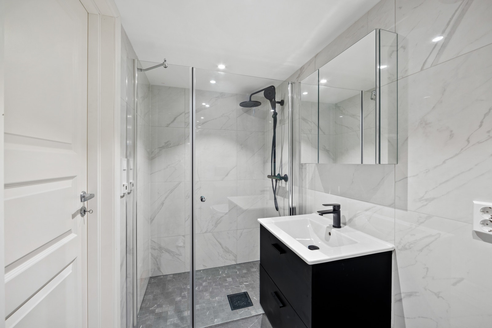 Meget eksklusivt flislagt bad med sorte detaljer og varmekabler på gulv. Stor dusj. Galleribilde