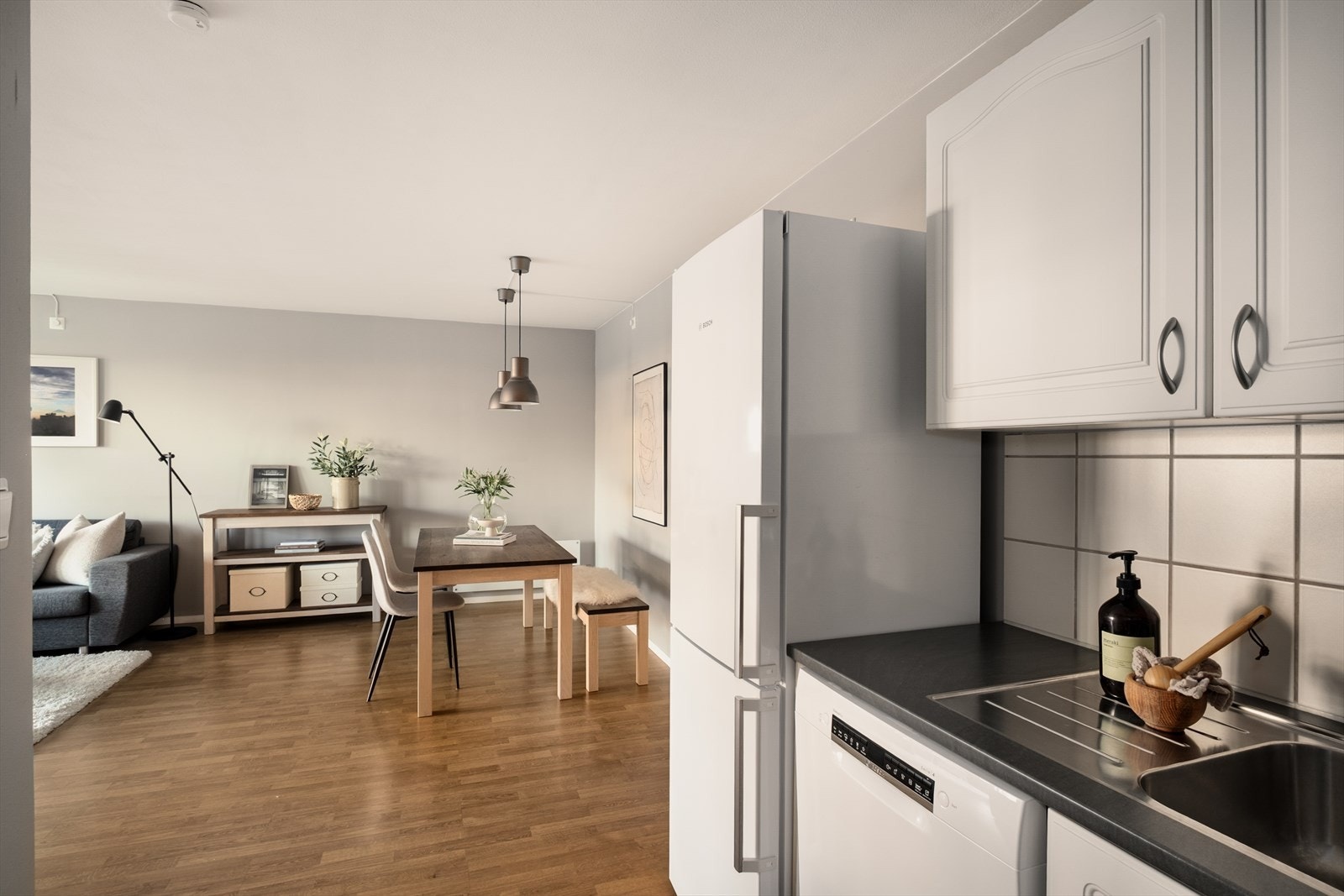 Leilighetens kjøkken er innredet med med profilerte hvite fronter, laminert benkeplate og opplegg for oppvaskmaskin. Oppvaskmaskinen og kjøleskap medfølger handelen. Galleribilde