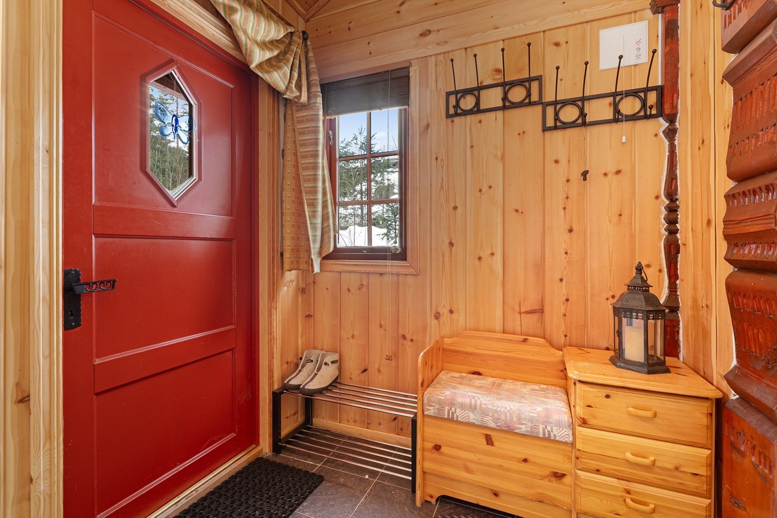 Hyggelig vindfang med fin plass til både sko- og yttertøy. Overflater består av flis på gulv, trepanel på vegg samt trepanel i himling. Galleribilde