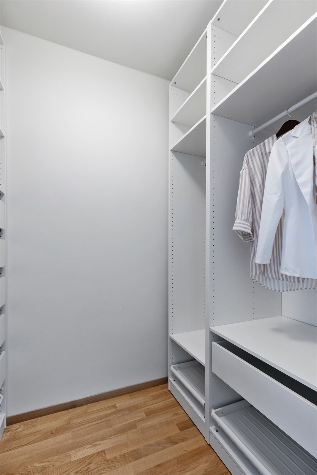 Lyst og romslig garderoberom med godt utnyttet innredning, hyller og skuffer som gir svært god oppbevaringskapasitet. Galleribilde